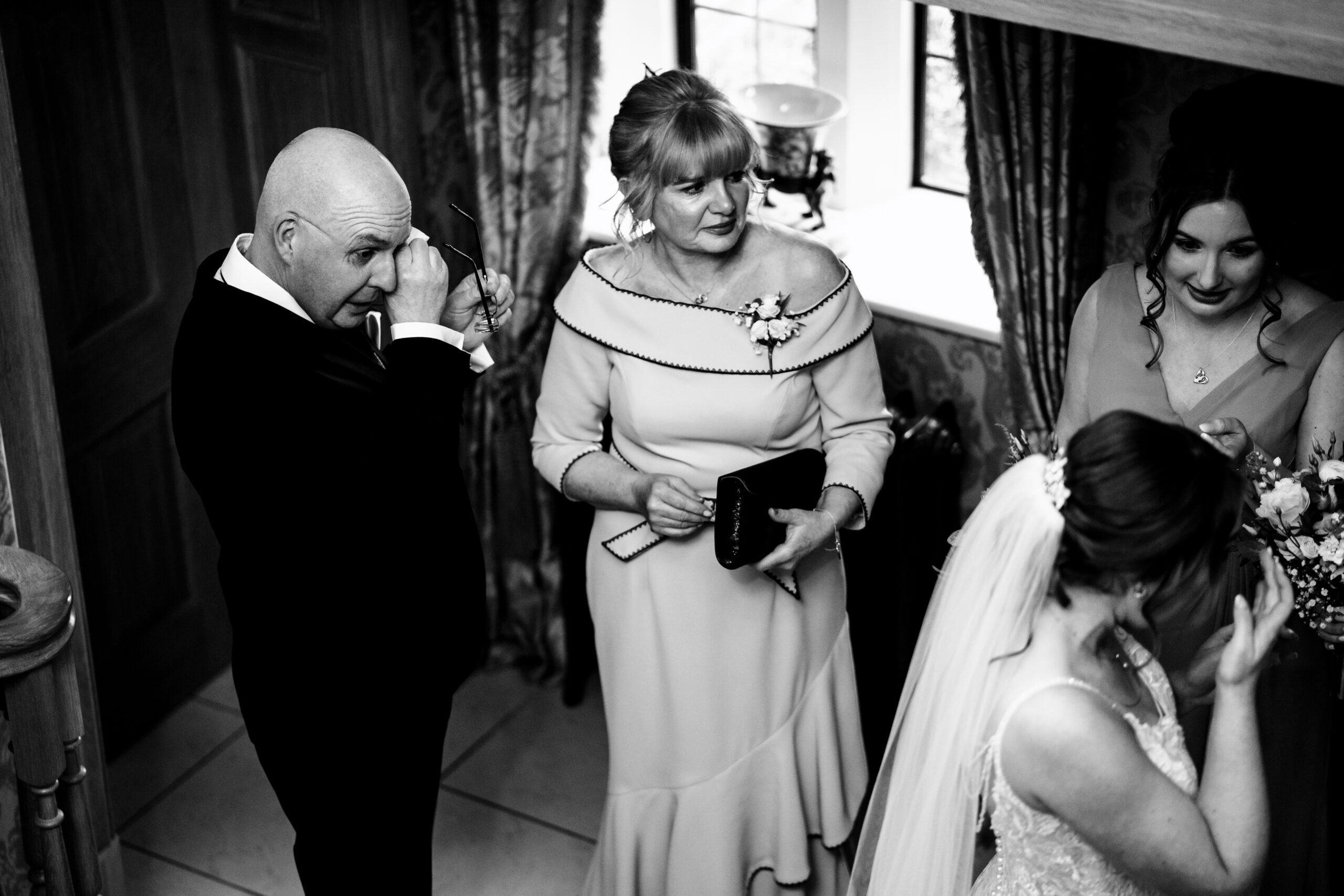 Black and white photo of Bethany's dad wiping his eyes while her mum looks on