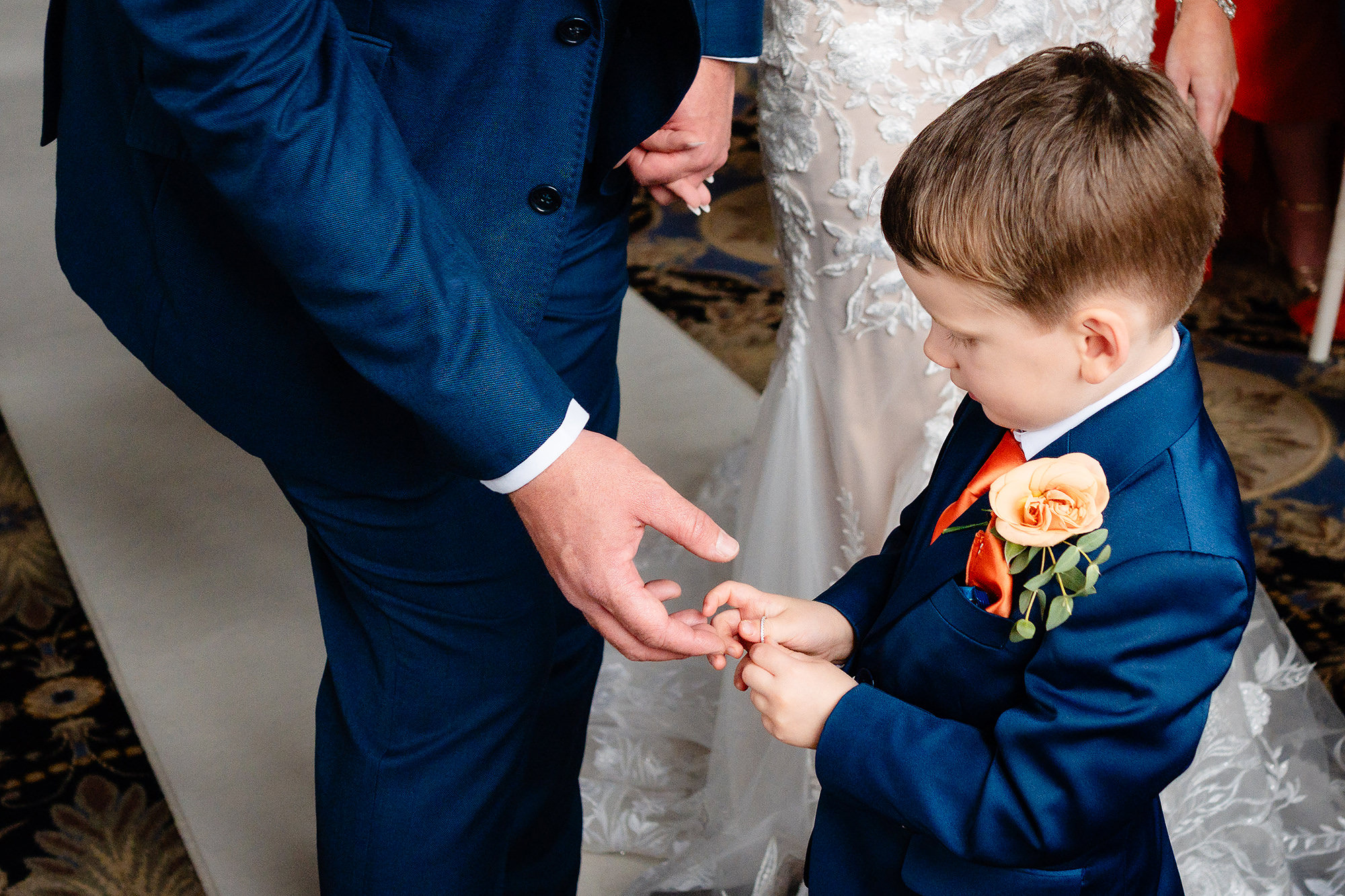 Alexander handing the wedding rings up to his dad during the ceremony at Crewe Hall