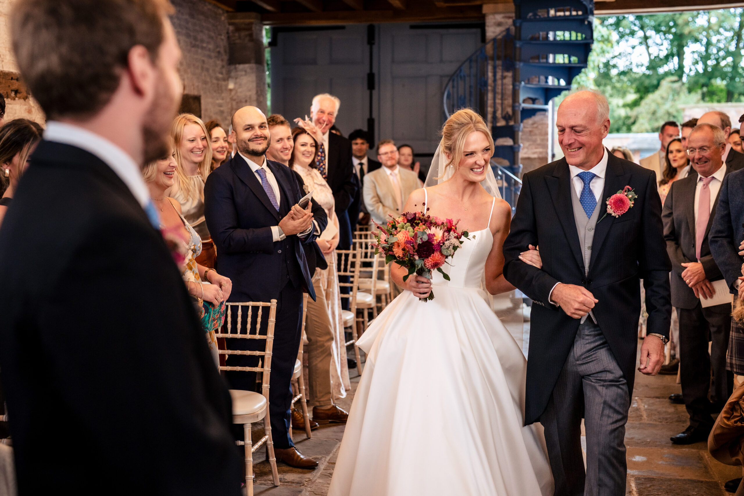 Bride walking down the aisle on her dad’s arm at the Coach House, Dorfold Hall