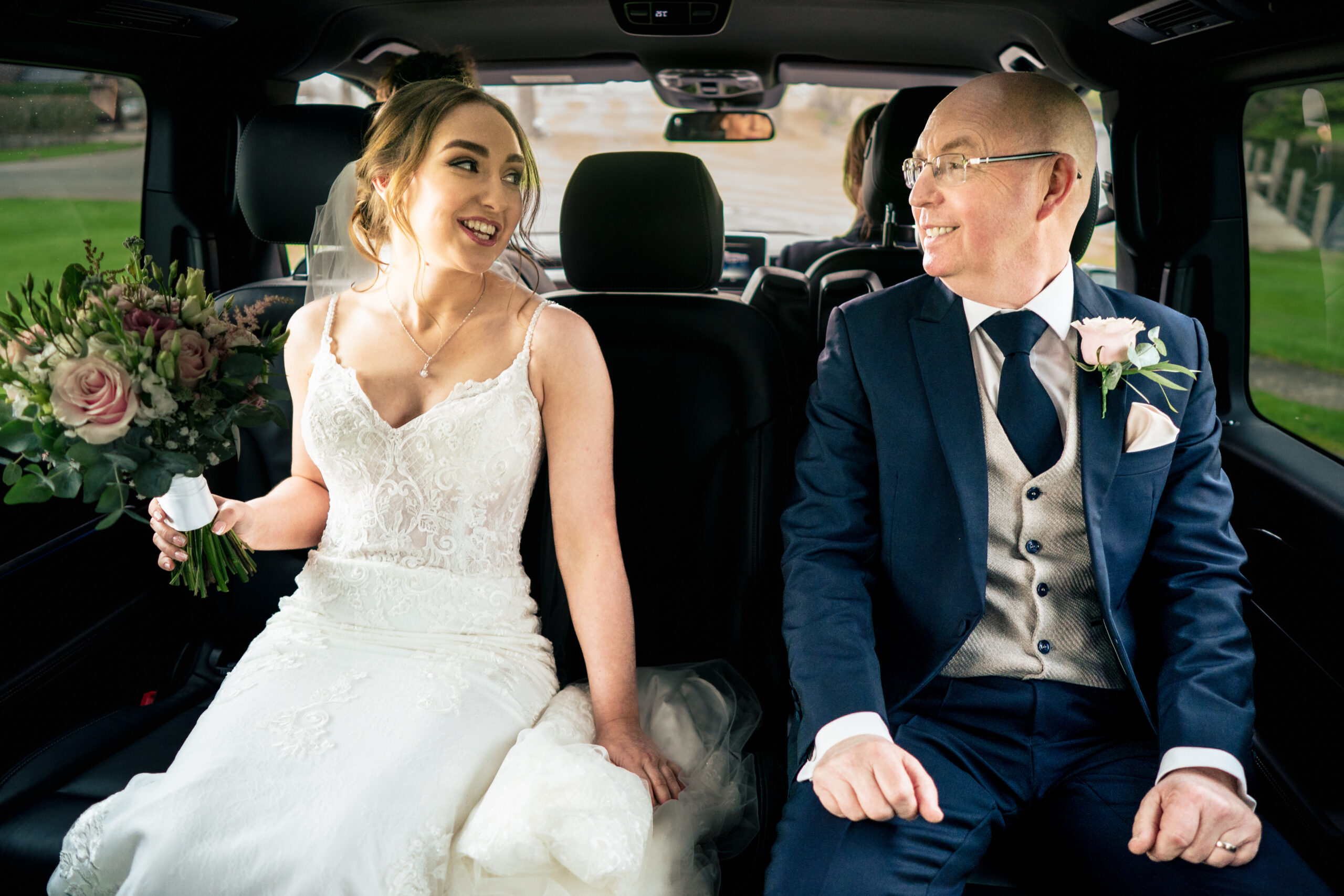 Bethany and her dad laughing in the back of the car on the way to the Ceremony Room
