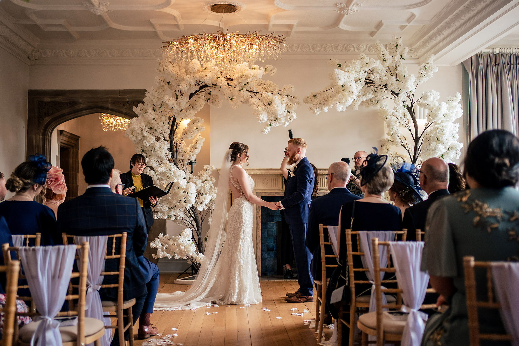 Patrick and Laurel exchanging vows under the cherry blossom arch at Salt House, Staffordshire wedding photographer