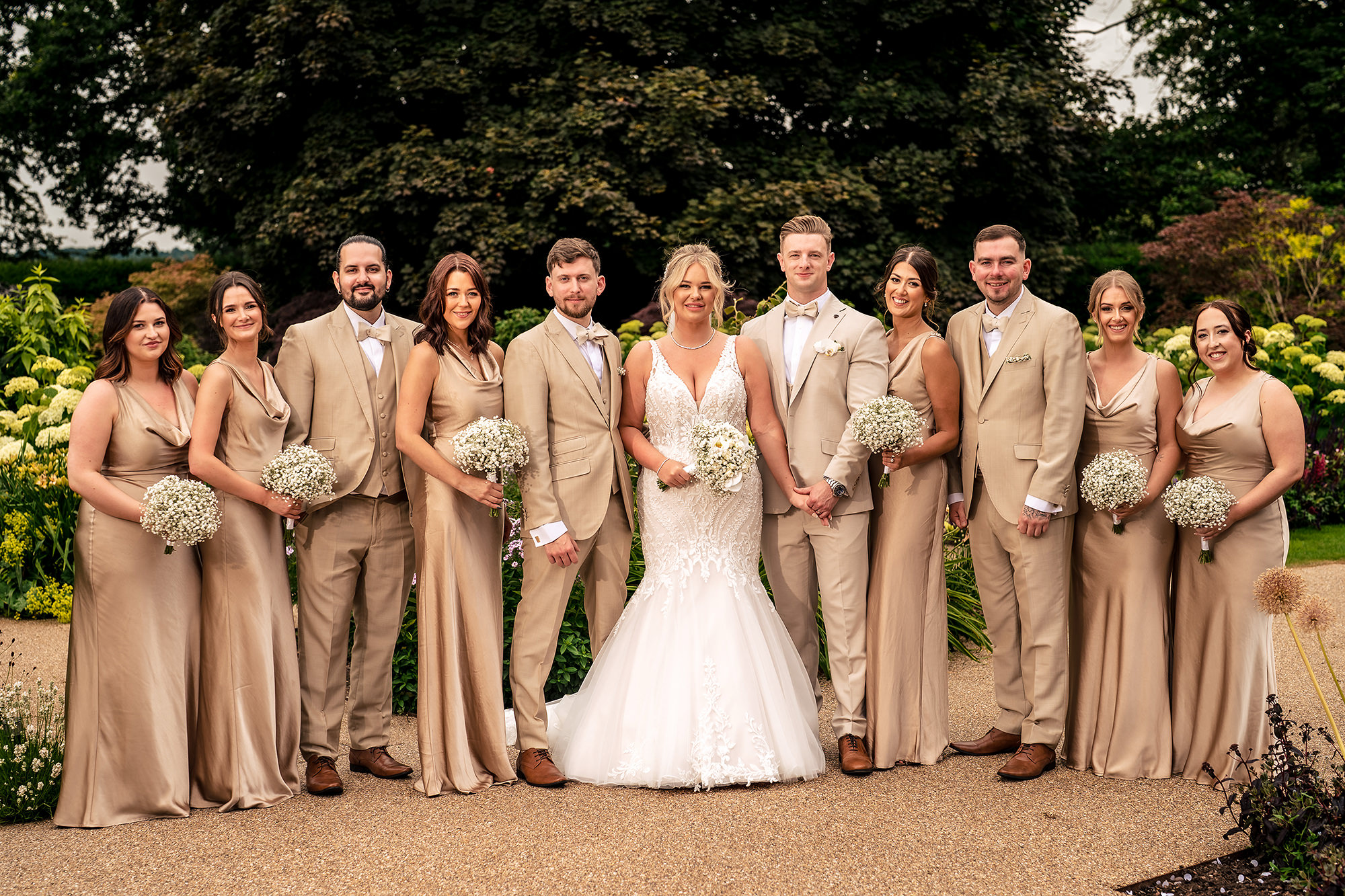The full bridal party in coordinating champagne and tan tones at Salt House, Staffordshire