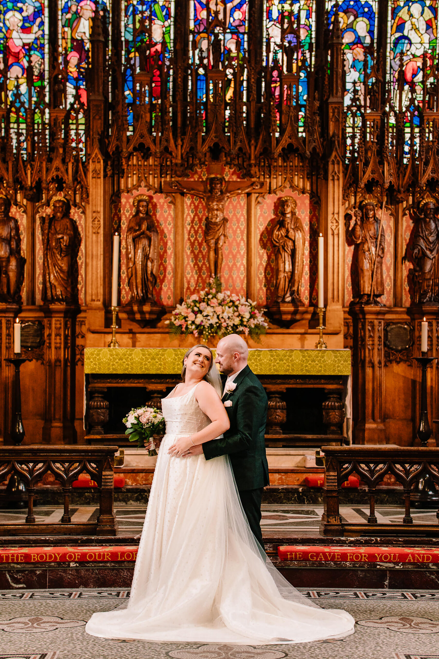 A close portrait of Chloe and Pete at the altar in front of St Mary’s ornate gold reredos