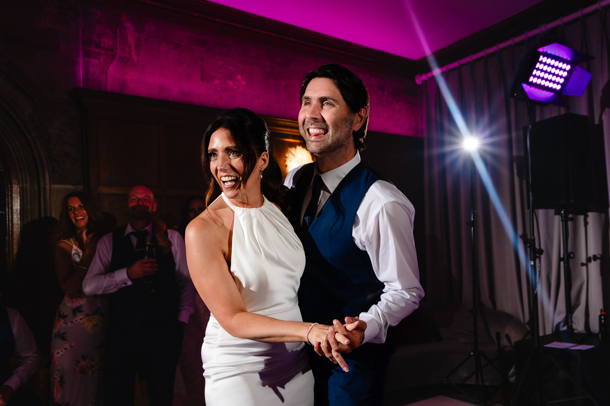 Bride and groom on the dance floor under coloured lights during their first dance, Salt House Staffordshire wedding photographer