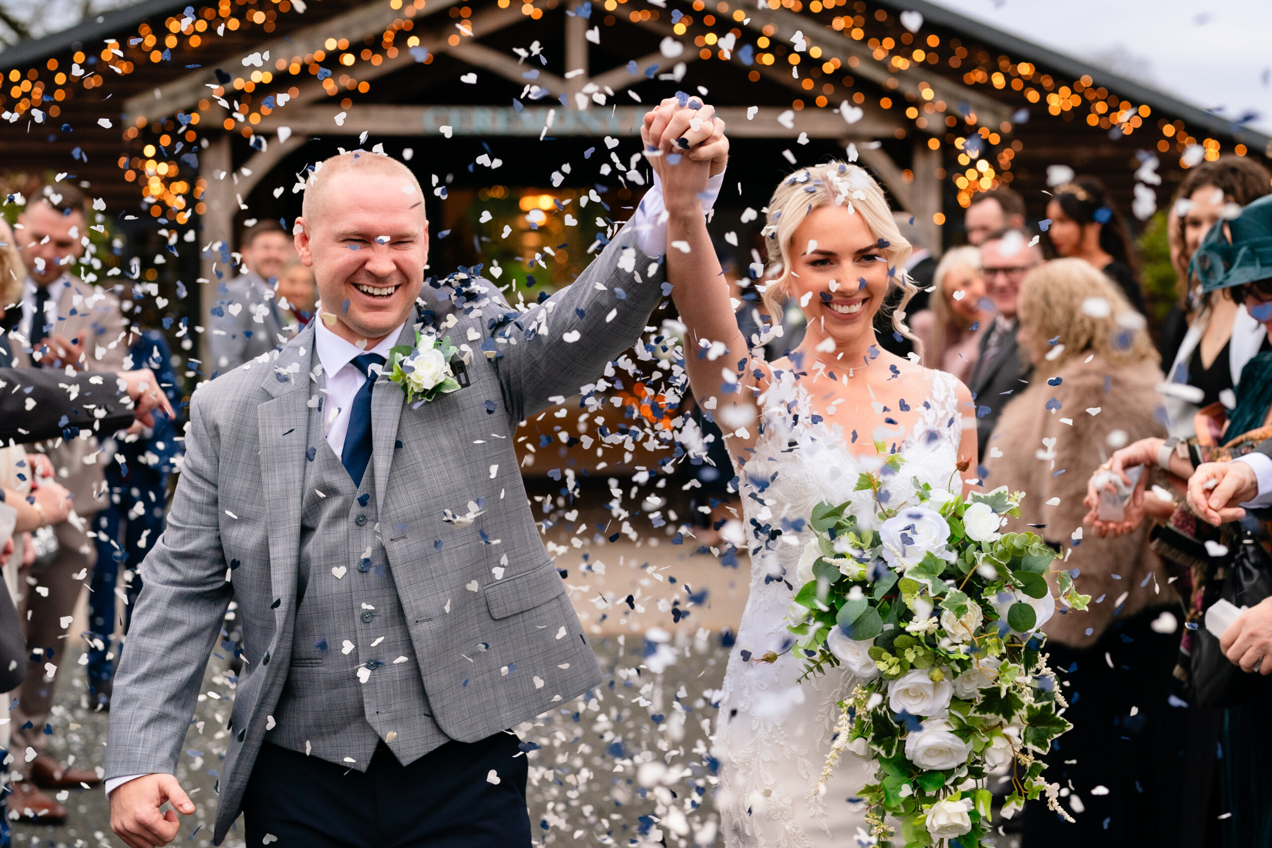 Close up of the bride and groom laughing as confetti falls all around them, Colshaw Hall wedding photographer