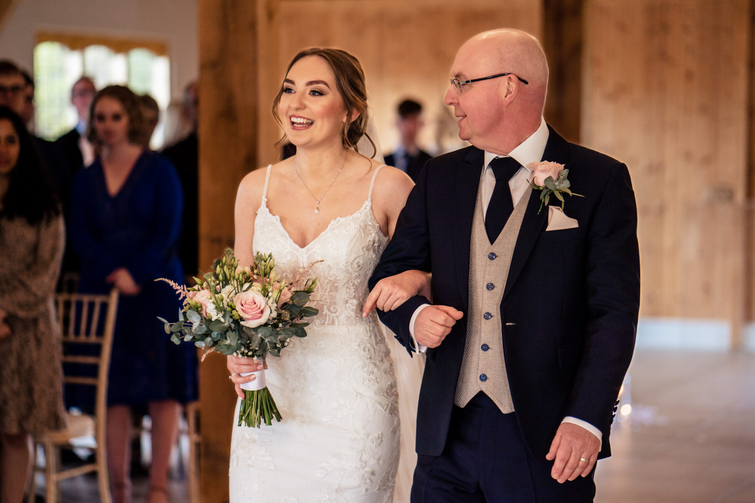 Bethany walking down the aisle on her dad's arm, both smiling, Merrydale Manor wedding photographer