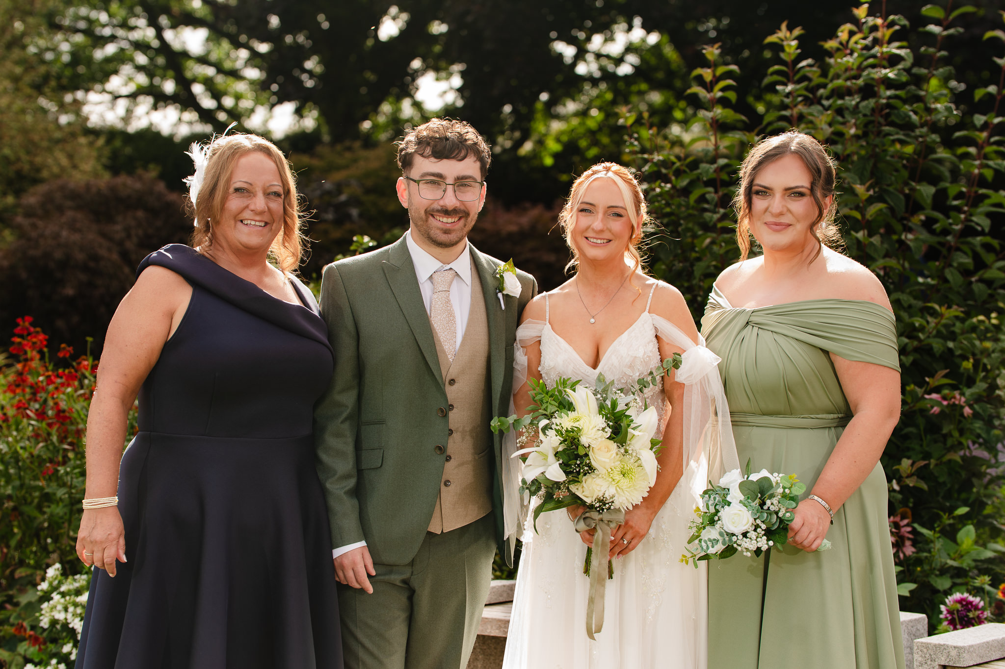 Bride and groom with a small family group posing together