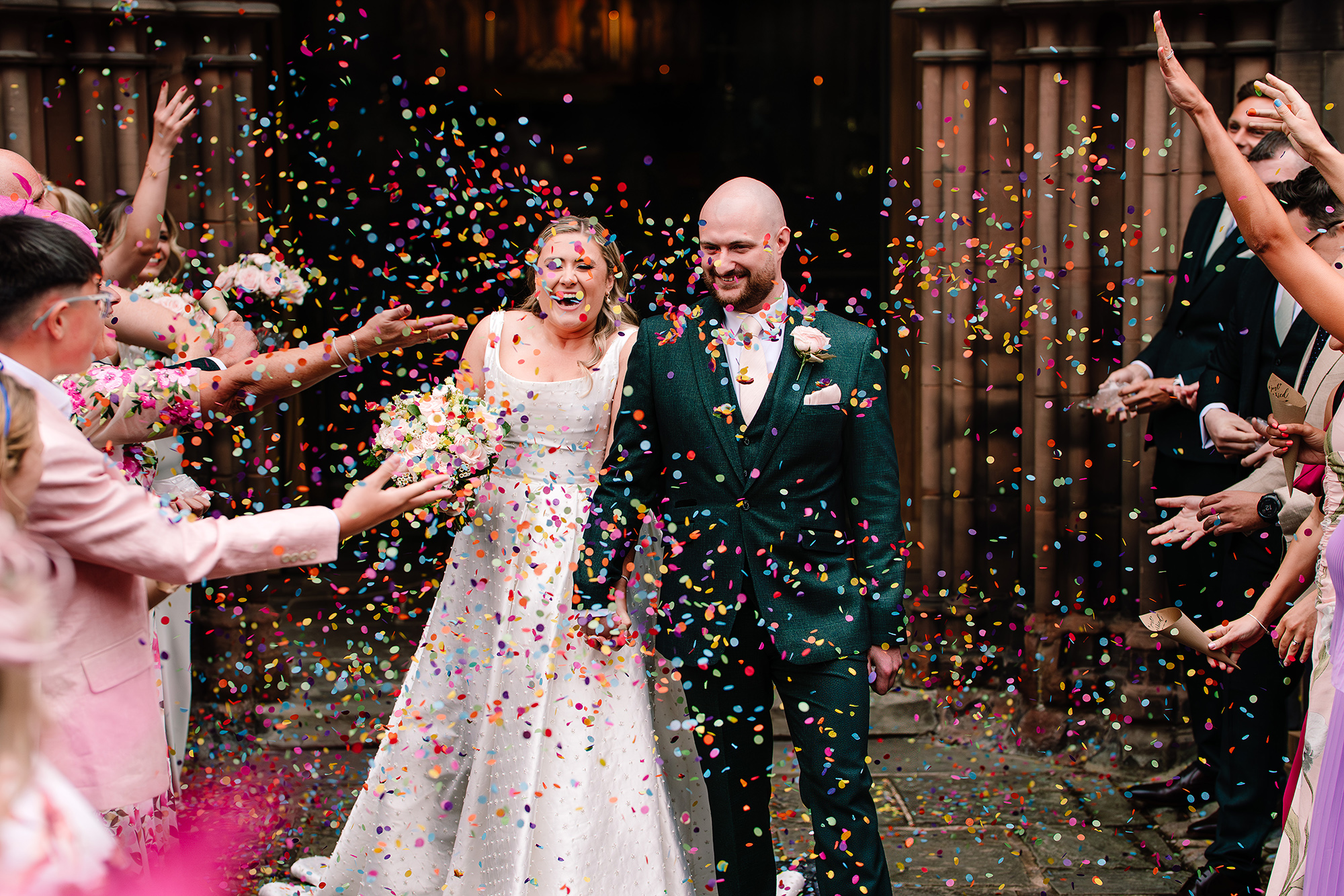 Confetti exploding over Chloe and Pete as they leave St Mary’s Church, Nantwich