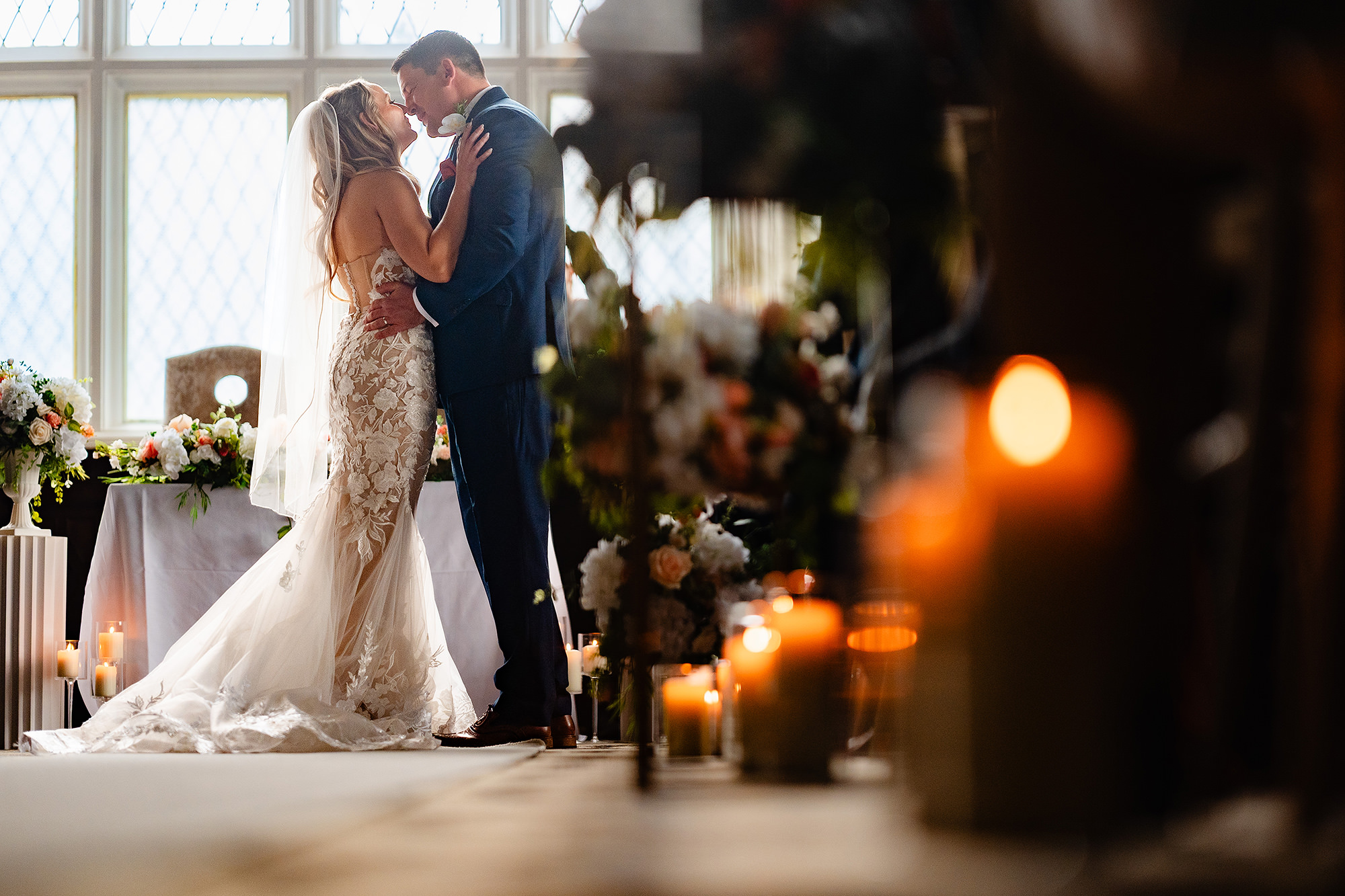 The couple’s first kiss as husband and wife, shot through a row of lit candles in the Drawing Room