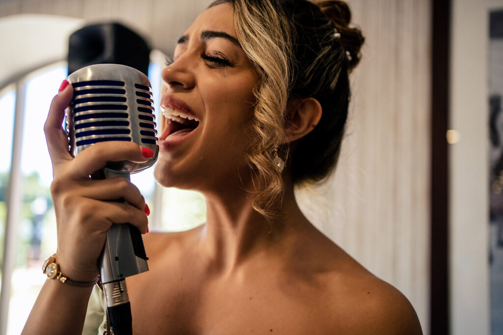 Singer performing with a vintage microphone during the drinks reception at Merrydale Manor