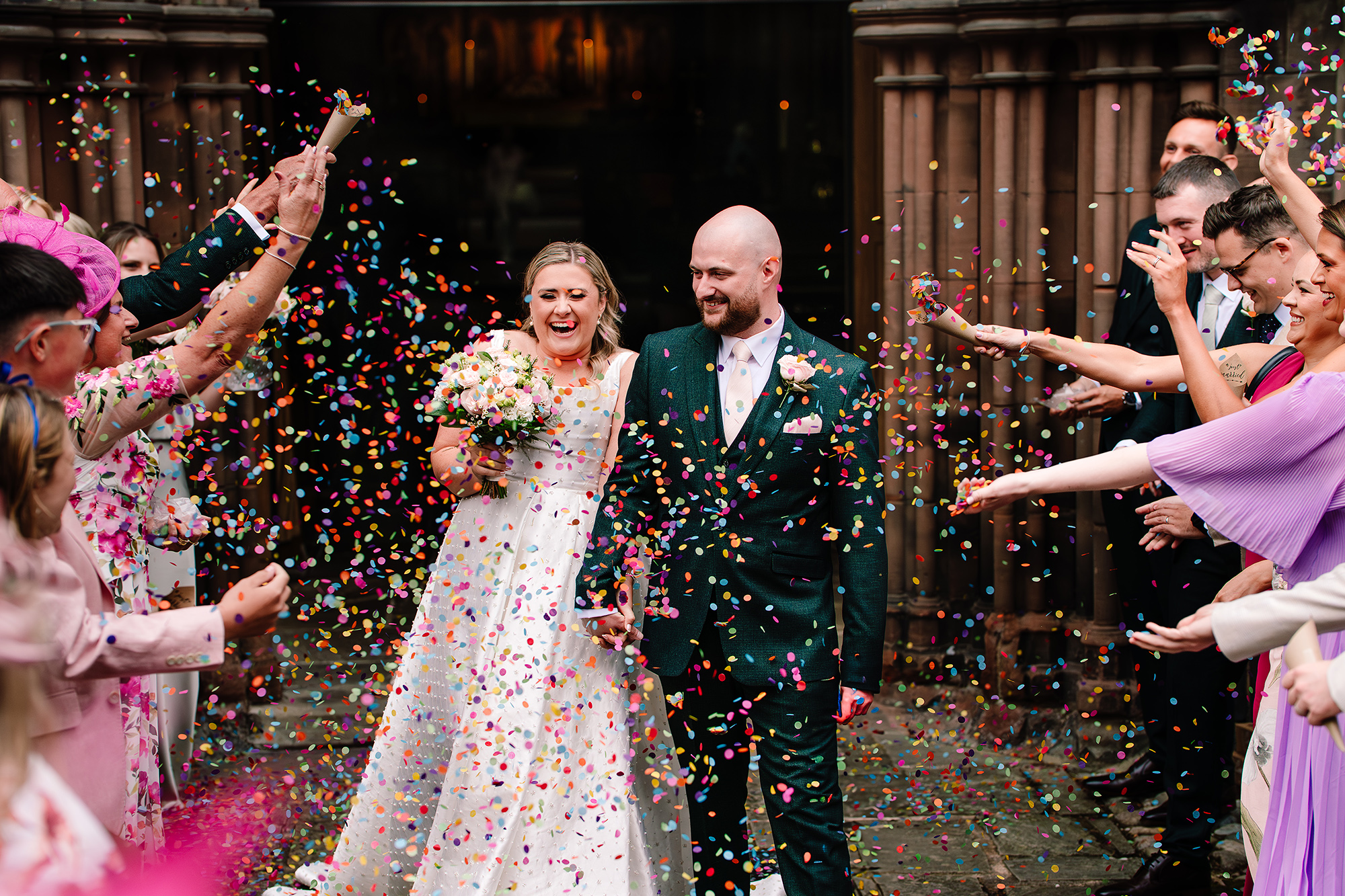 Confetti caught mid air around the newlyweds outside the church