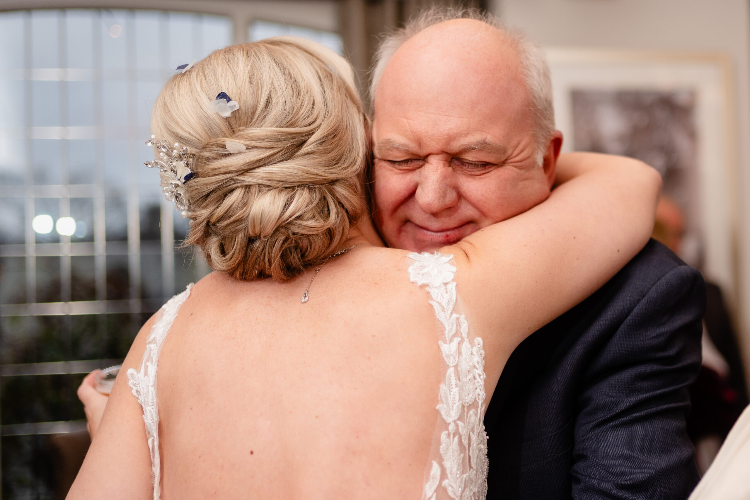 The bride's dad closing his eyes as he hugs her during the drinks reception, Colshaw Hall wedding photographer