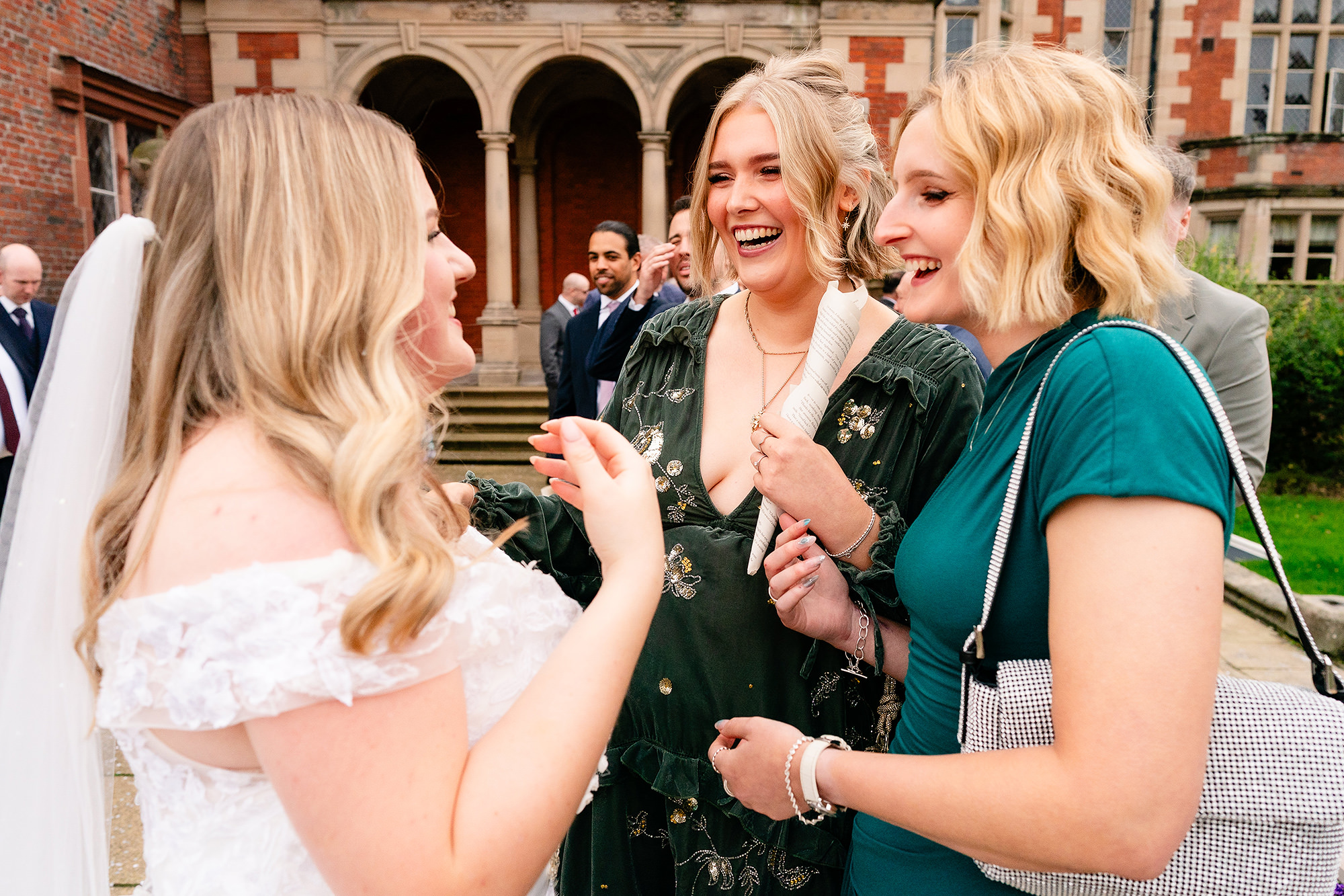 The bride sharing a laugh with her bridesmaids after the ceremony, Crewe Hall wedding photographer