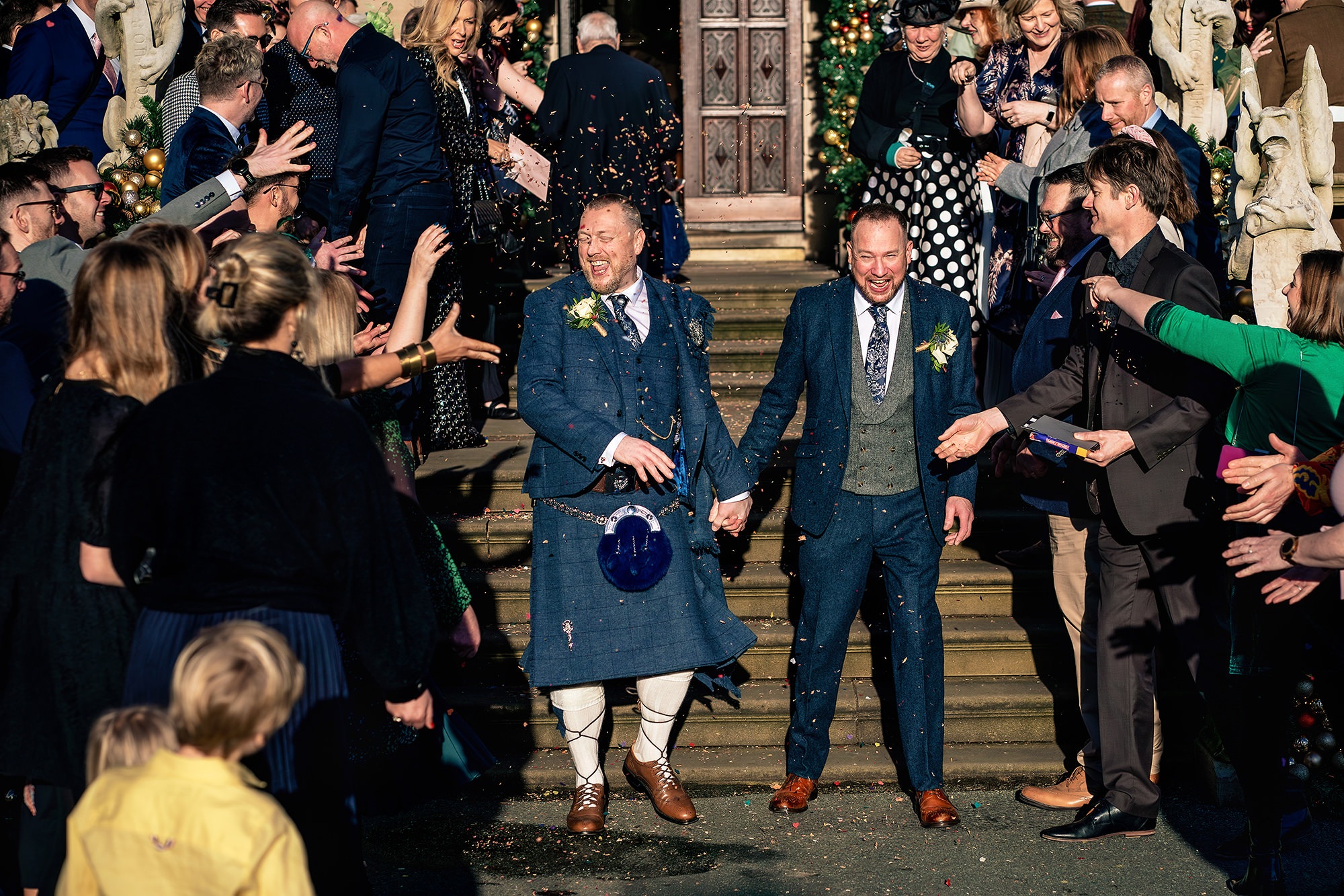Confetti still falling as John and Neill made their way down the grand steps at Crewe Hall