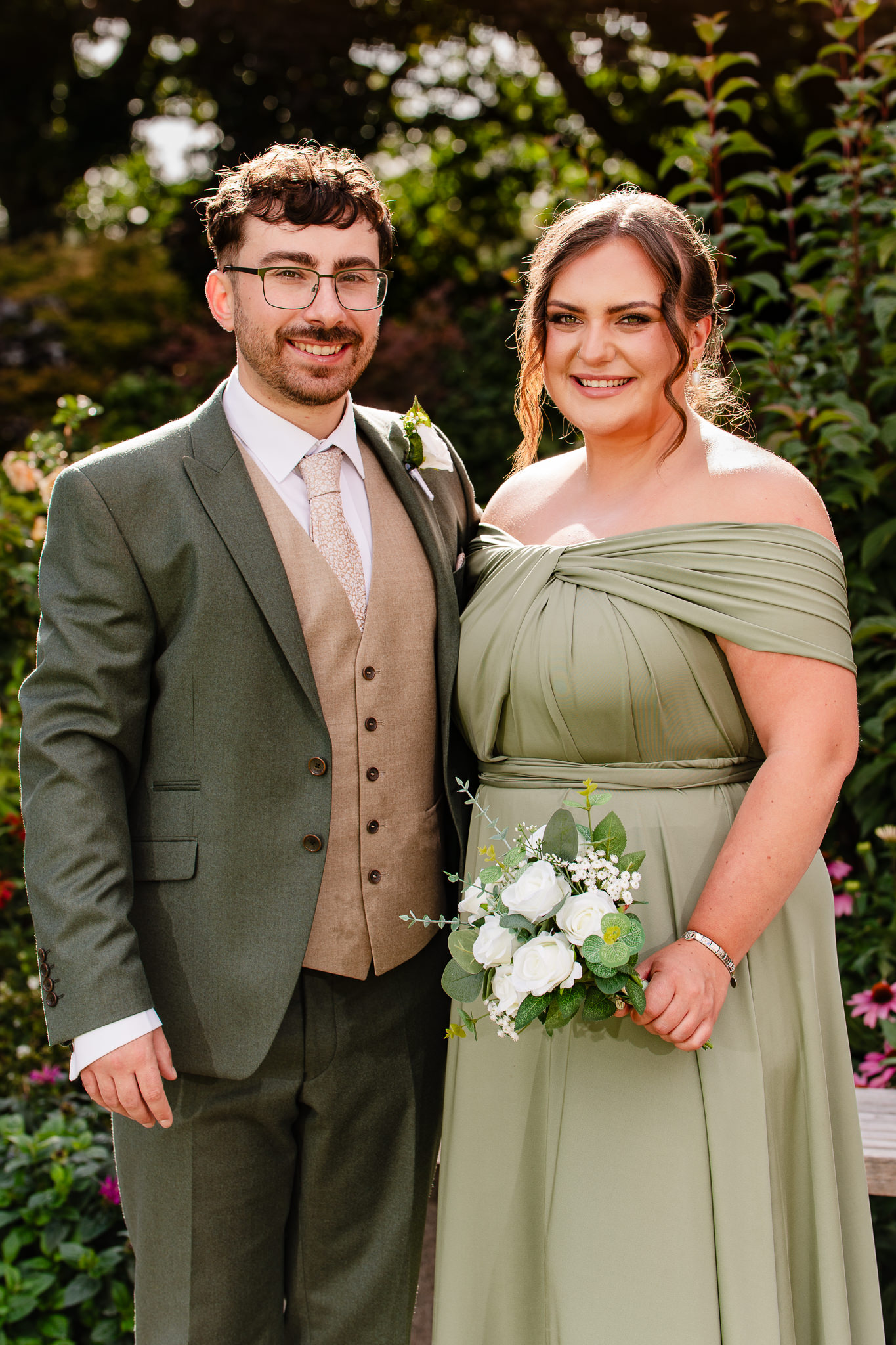 The groom with one of the bridesmaids, a relaxed portrait in the gardens at Salt House
