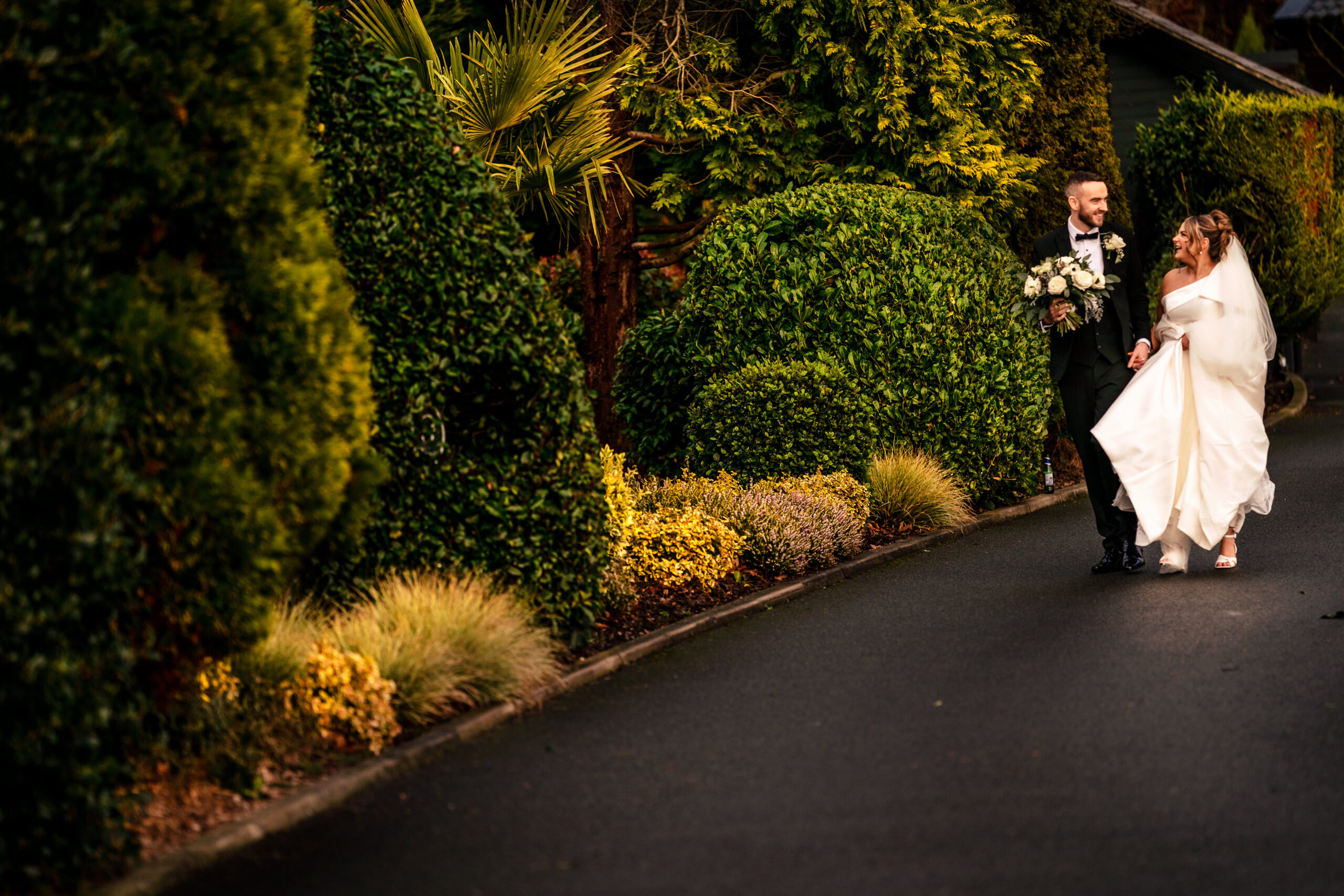 Georgia and Joe walking together through the gardens at Colshaw Hall