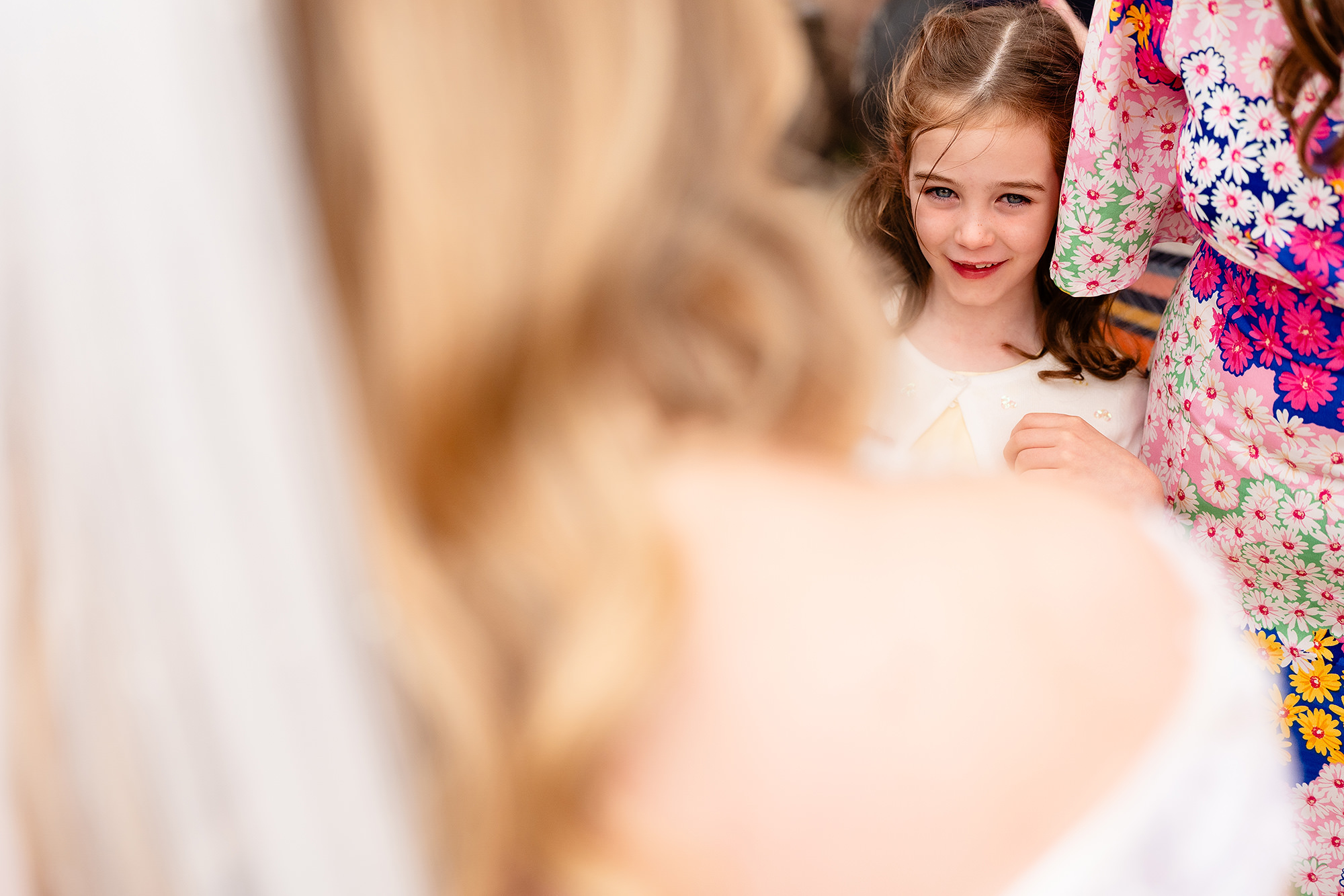 A young guest admiring the bride’s dress and hair after the ceremony, Crewe Hall wedding photographer