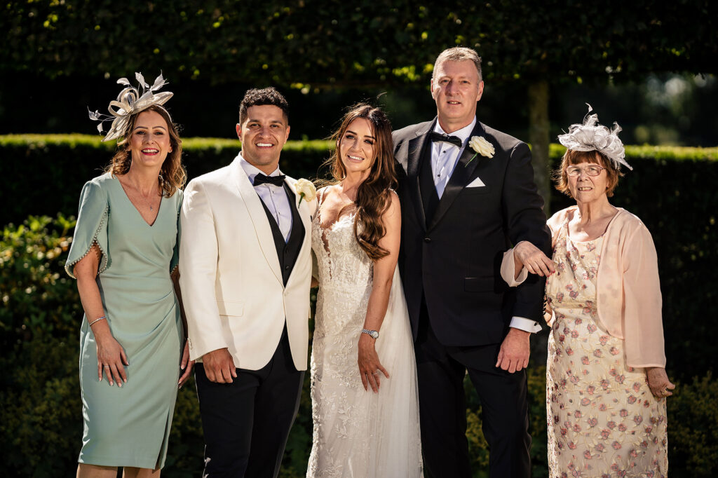 Gemma and Tyrone with Gemma’s mum and family in front of the hedges at Merrydale Manor