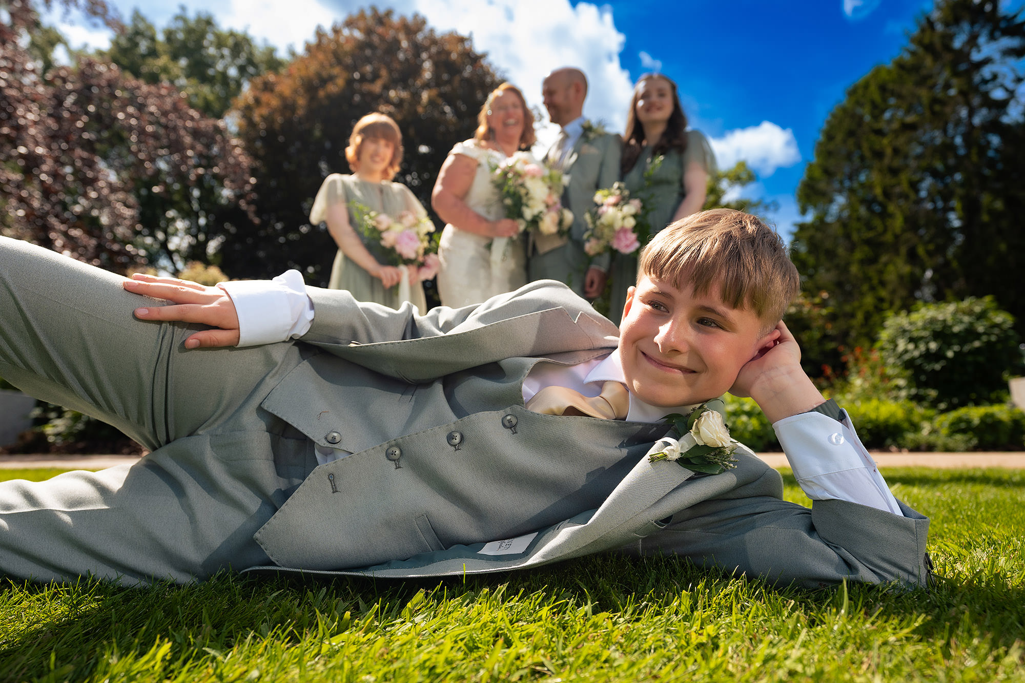 The bride’s son lying on the lawn in a playful moment during a break in the group photographs at Salt House
