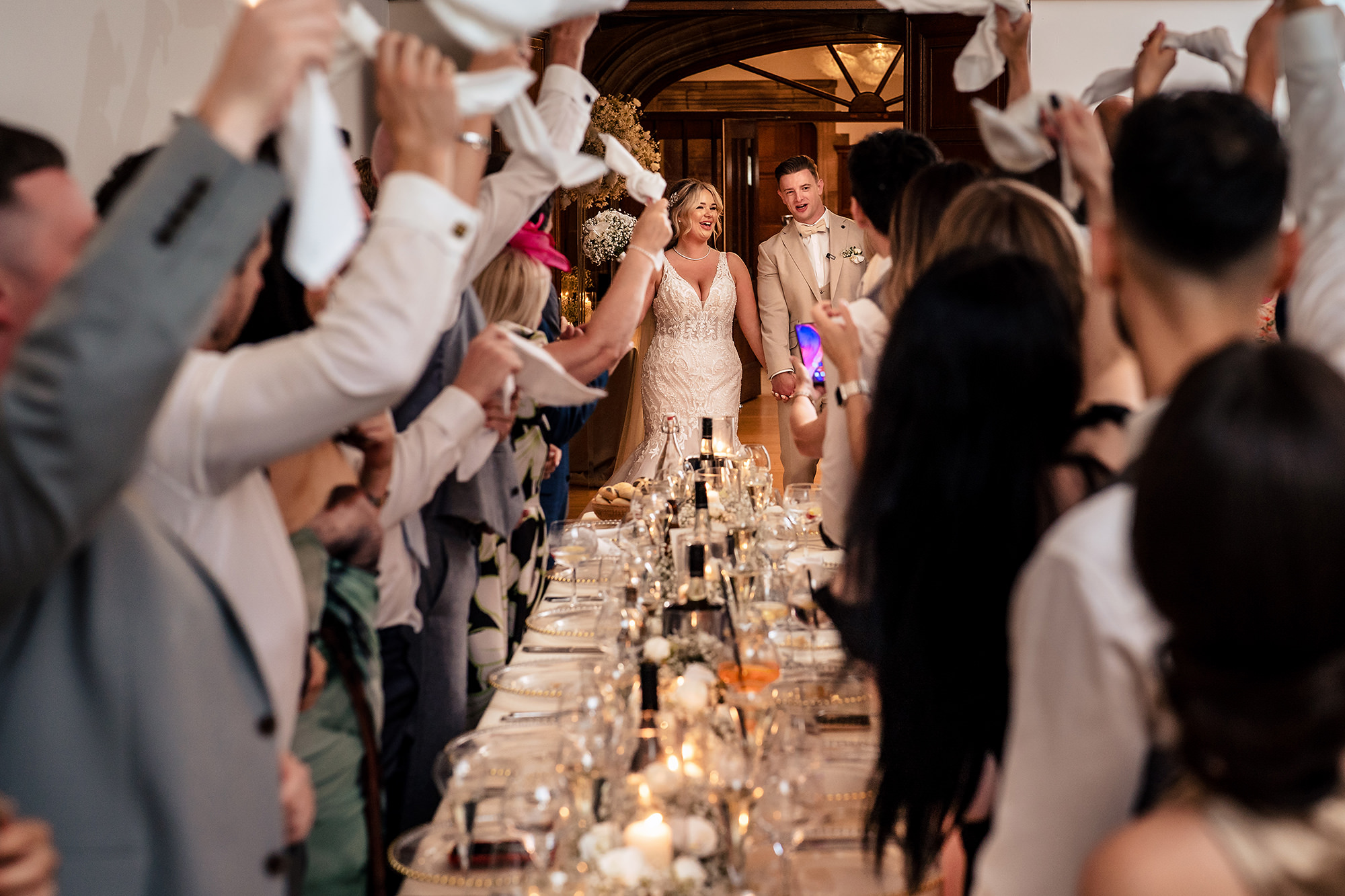 Guests waving napkins as Jess and Cy make their entrance to the wedding breakfast at Salt House