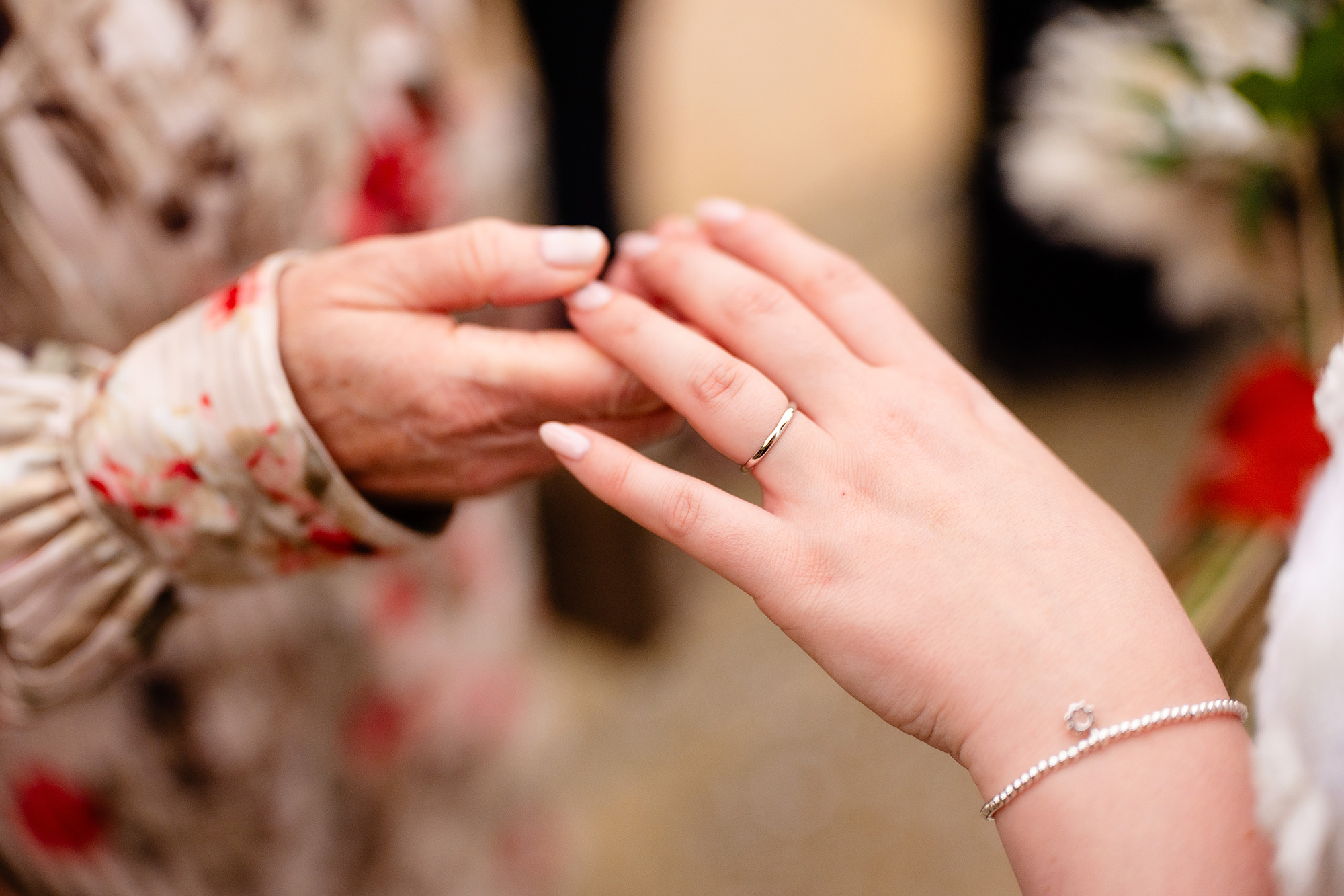 A guest holding the bride’s hand to admire her new wedding ring, Crewe Hall wedding photographer