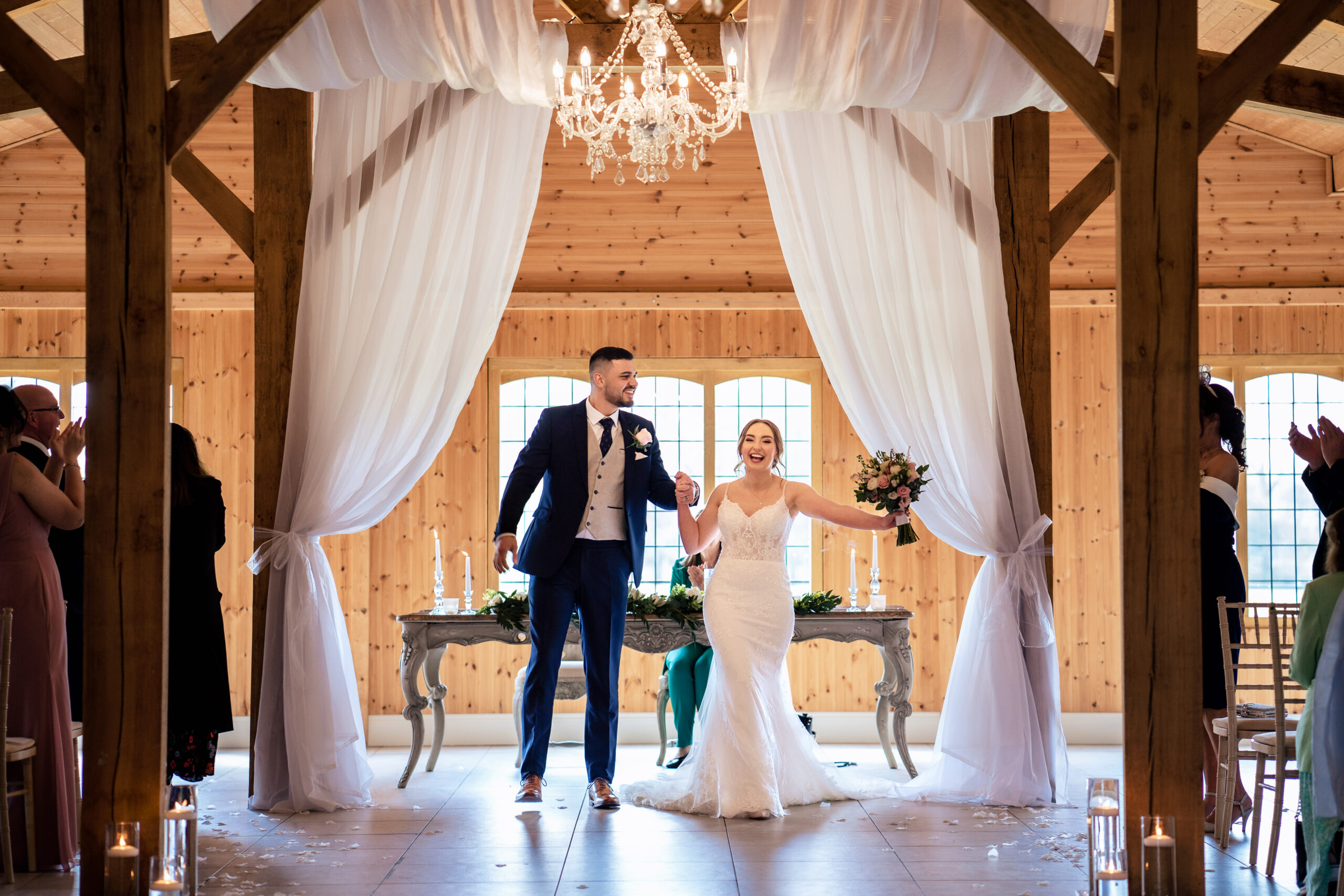 Bethany holding her bouquet up in the air as she and Dean walk back down the aisle married