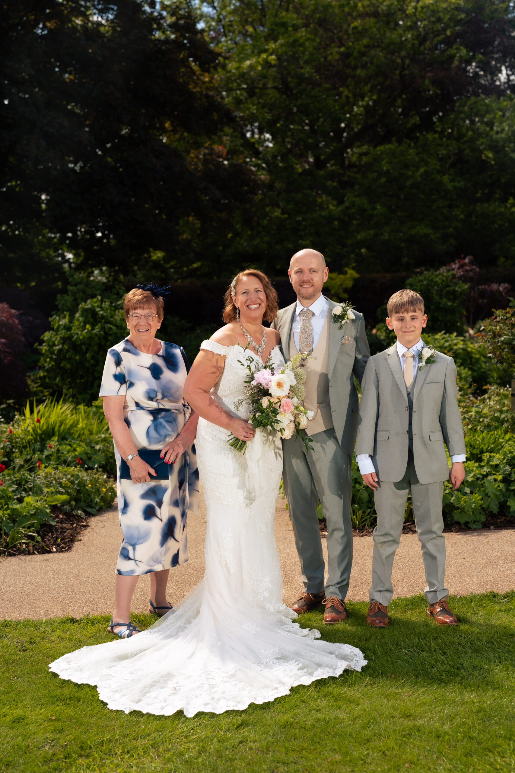 Bride and groom with the bride’s son and a family member posing for a family formal photograph at Salt House