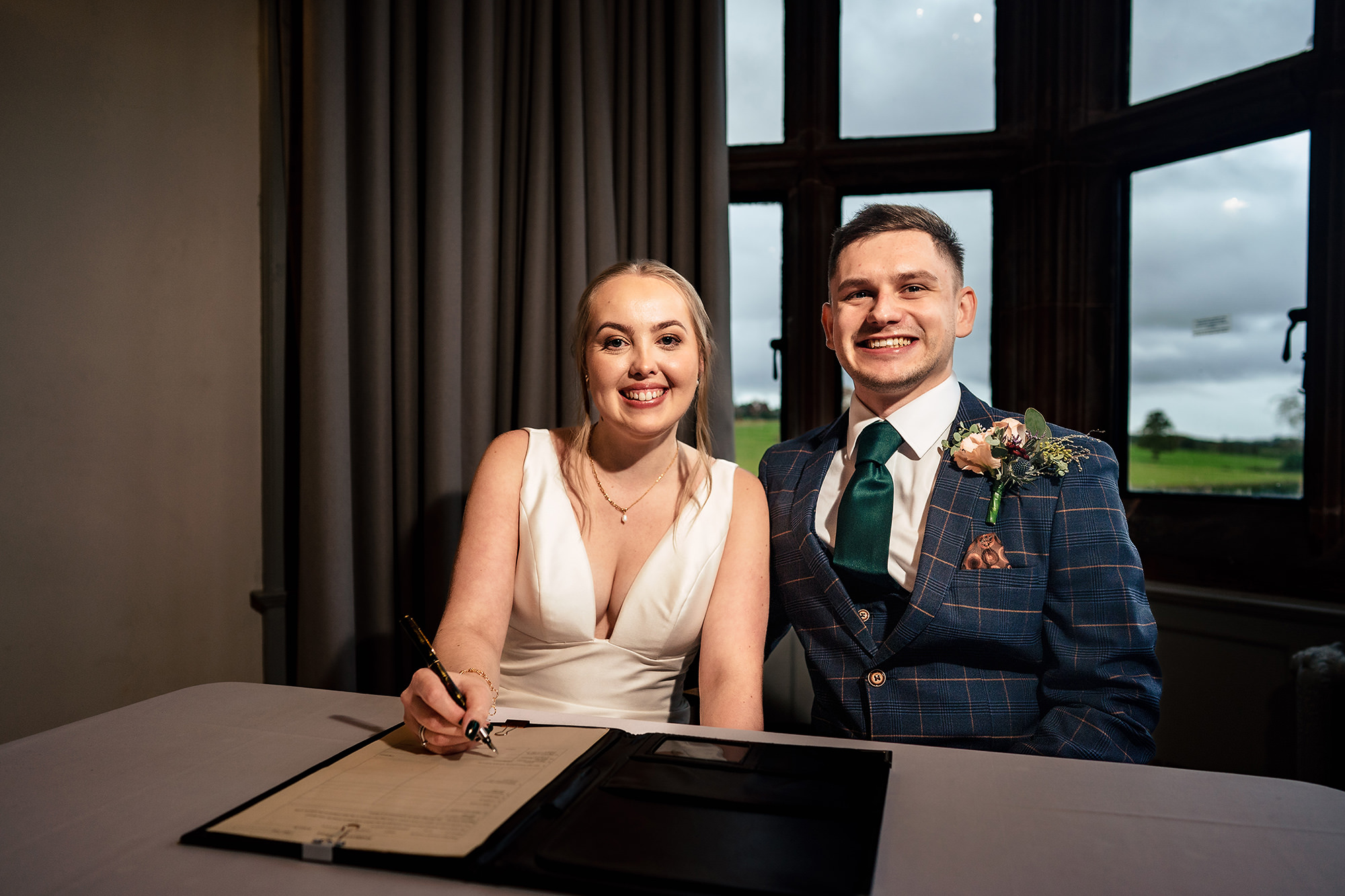 Chloe and Dan signing the register together by the window at Salt House