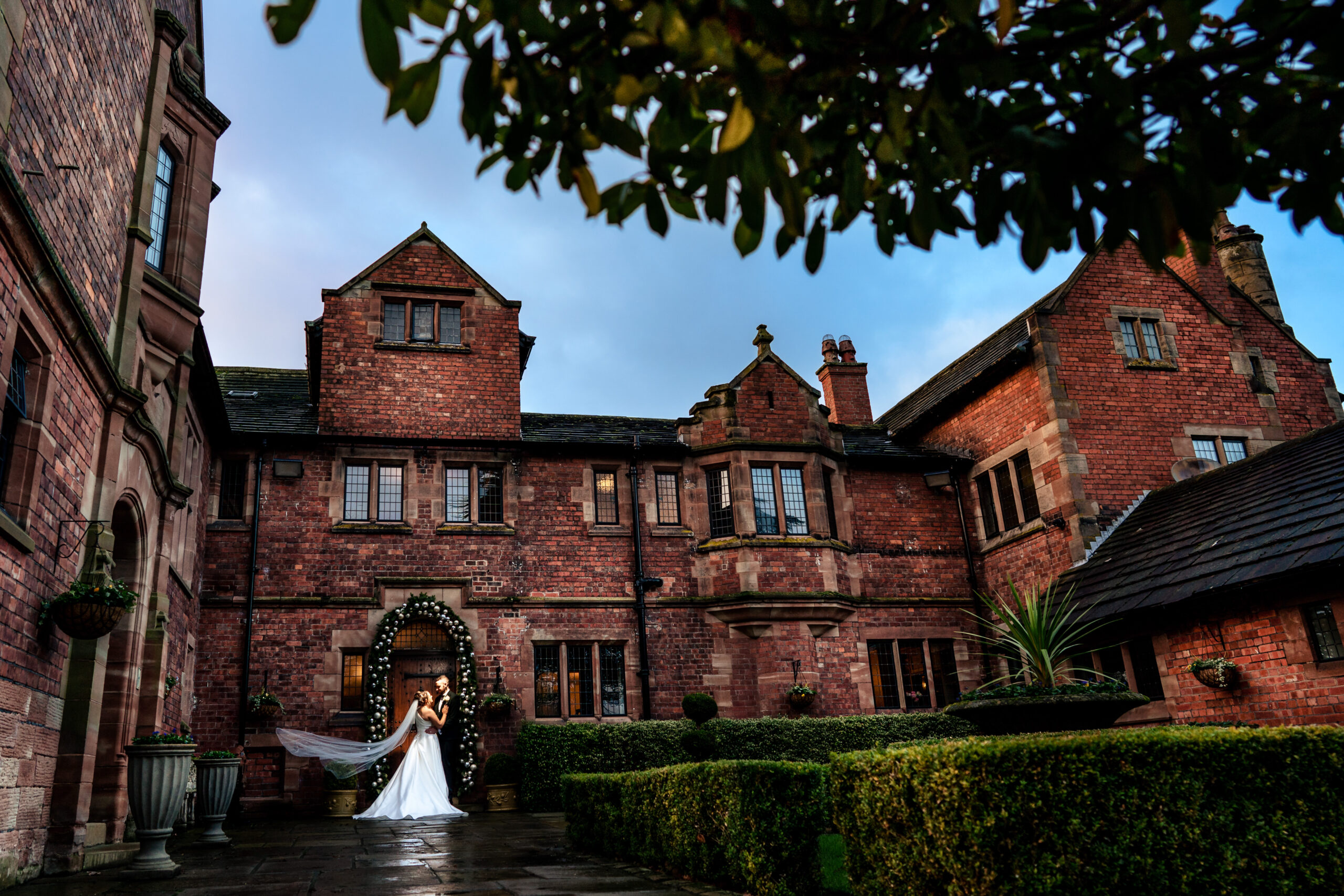 Georgia and Joe walking in the golden afternoon light in front of Colshaw Hall
