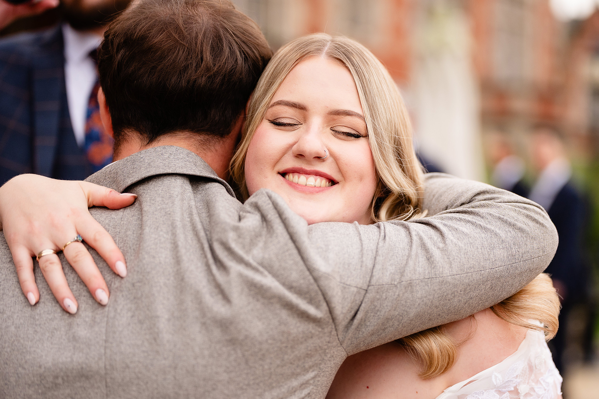 Tom, down to his waistcoat, sharing a tender embrace with Annie, Crewe Hall wedding photographer