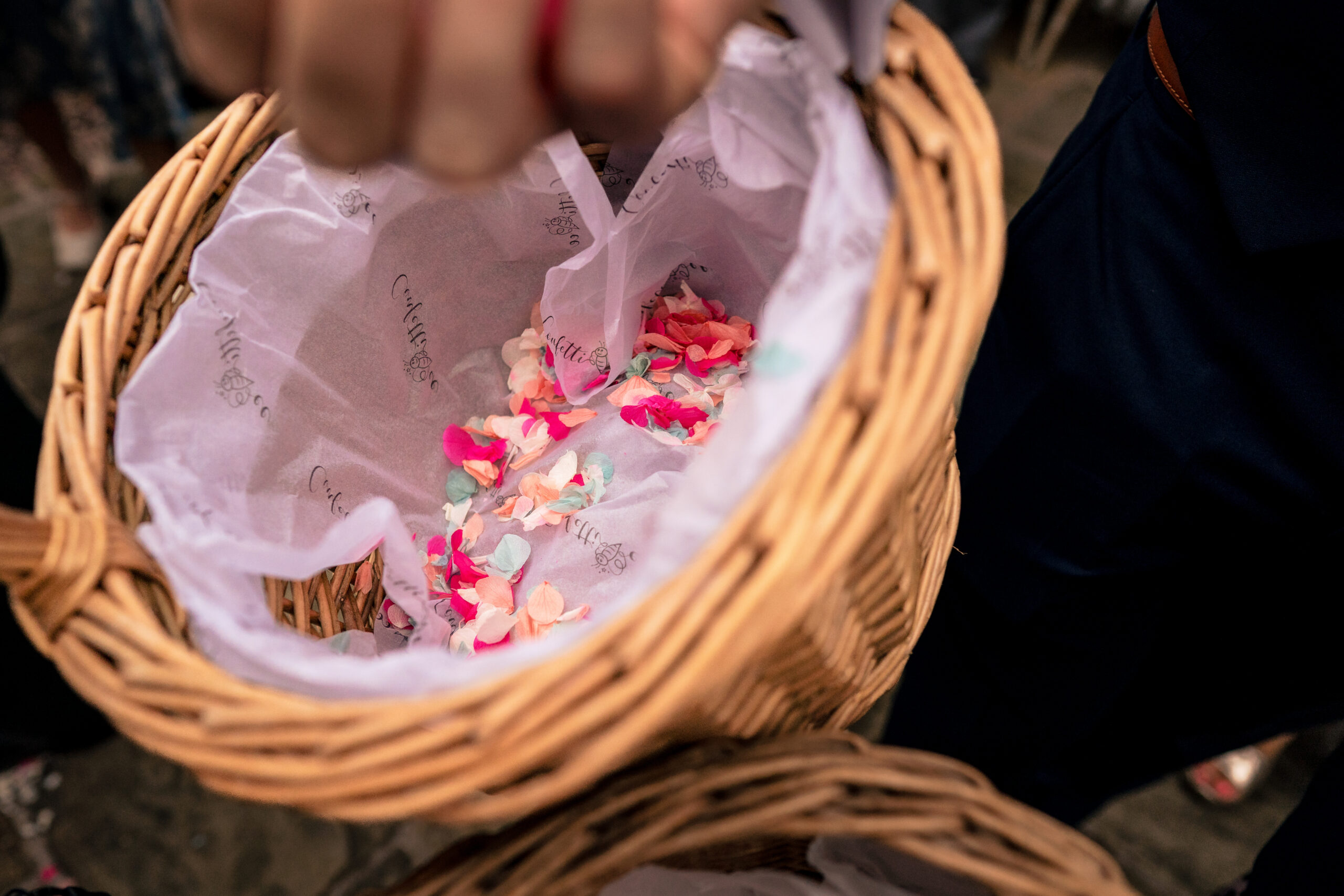 Wicker basket of pink and white petal confetti held ready outside the Coach House, Dorfold Hall