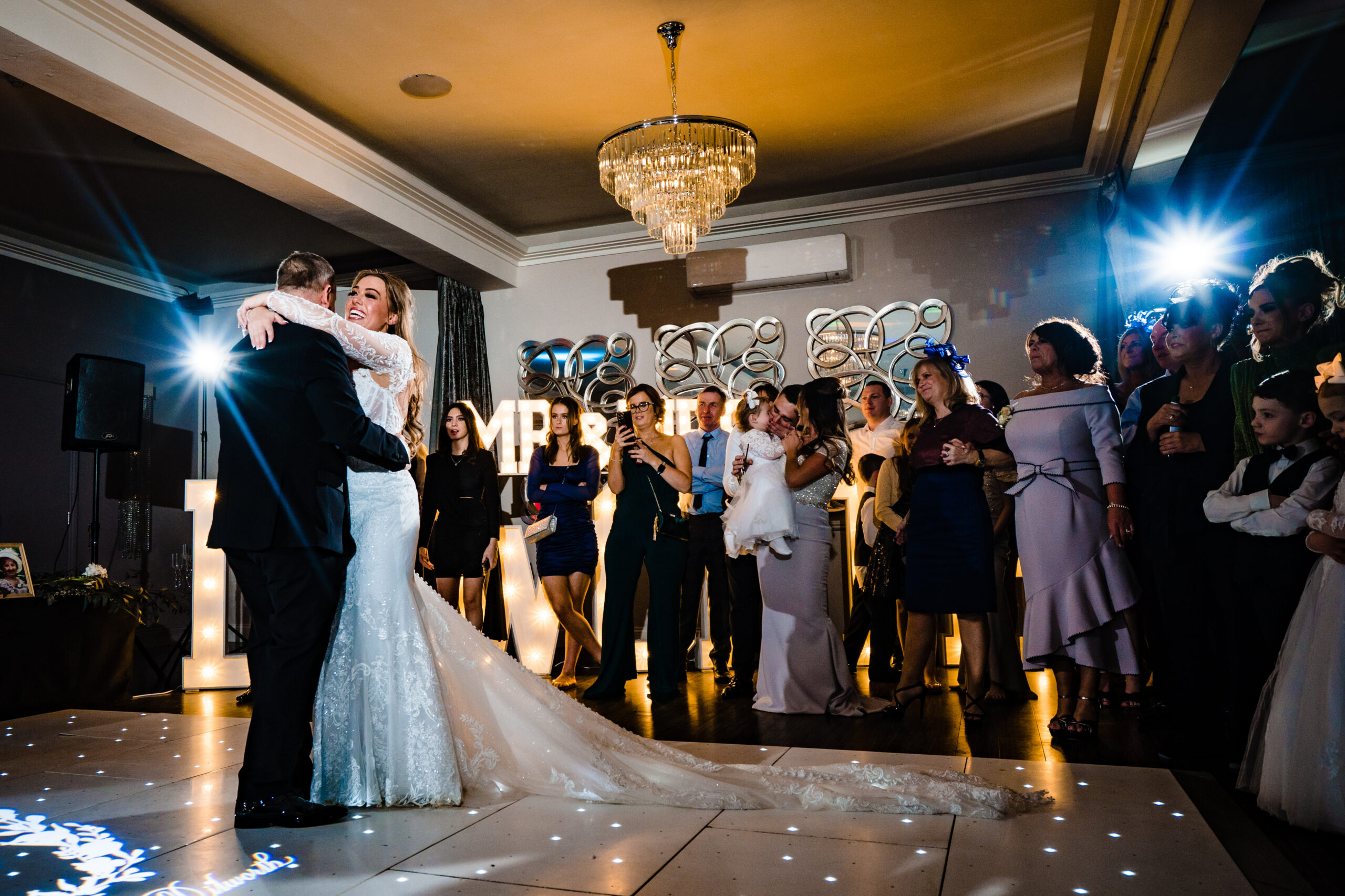 Abbie hugging her dad on the starlit dance floor as guests watch, Merrydale Manor