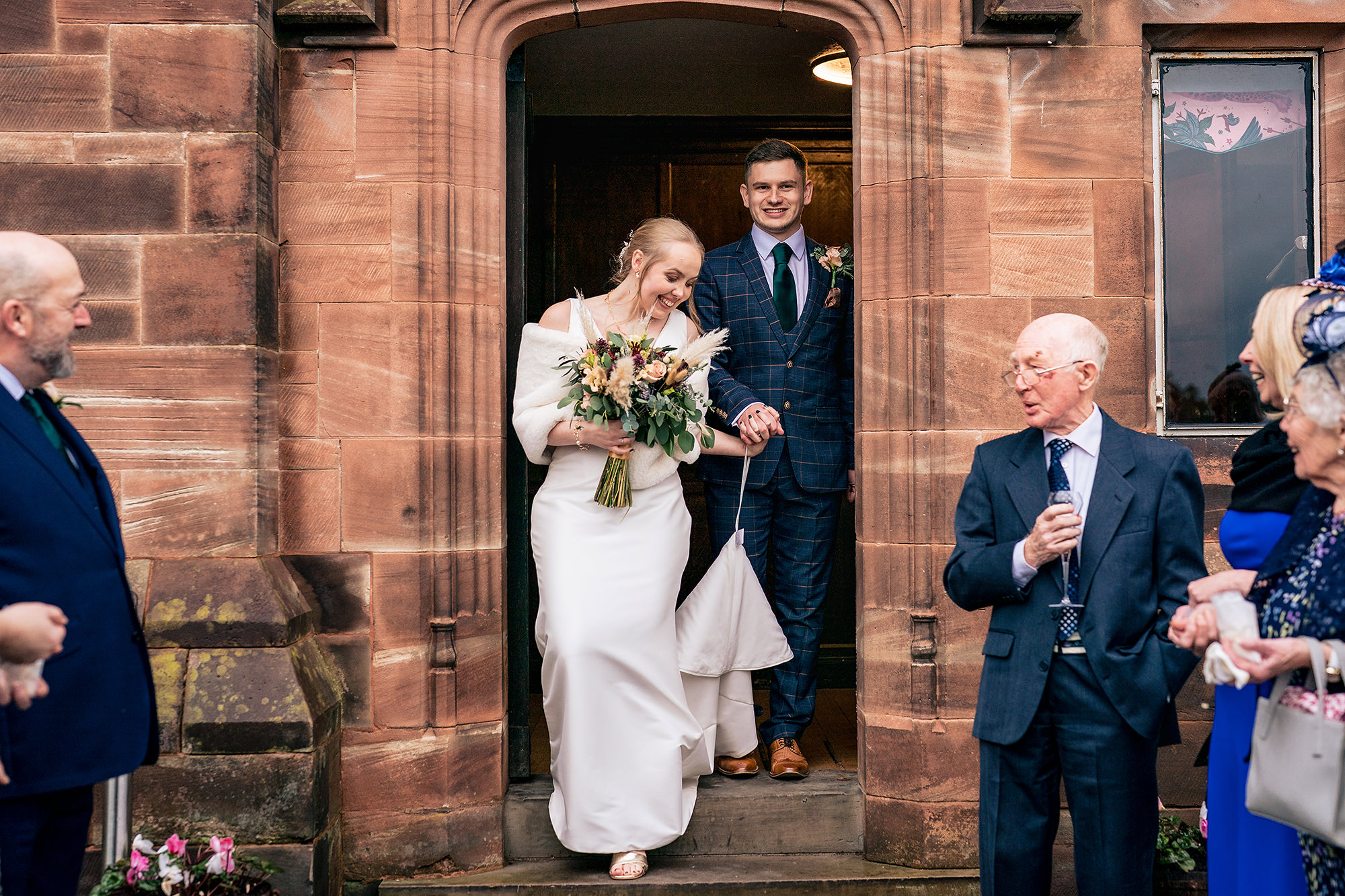 Chloe and Dan walking out through a confetti storm at Salt House