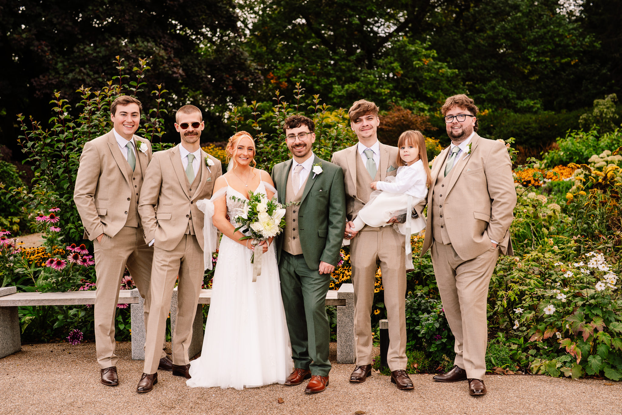 The groomsmen in tan suits gathered around the groom for a relaxed group photo