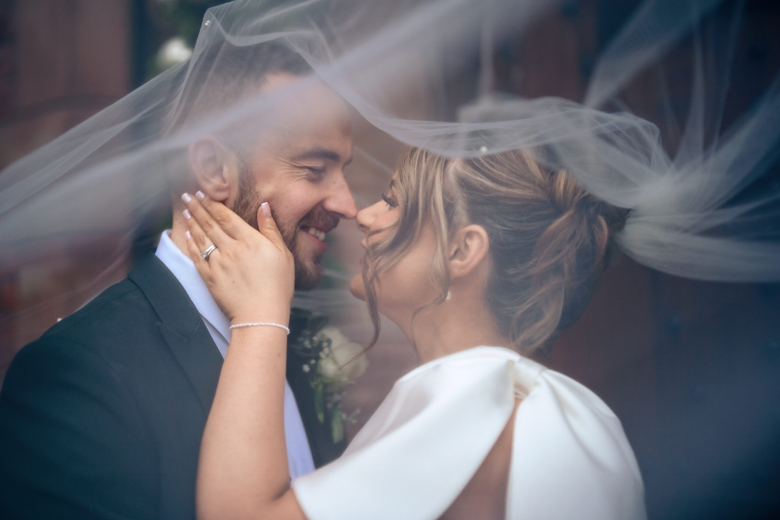 Georgia and Joe laughing together as her veil catches the breeze, Colshaw Hall wedding photographer