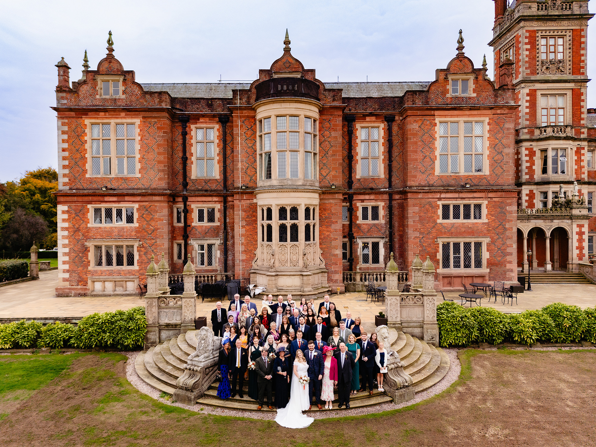Guests gathering on Crewe Hall’s lawn for the group photo, Cheshire wedding photographer