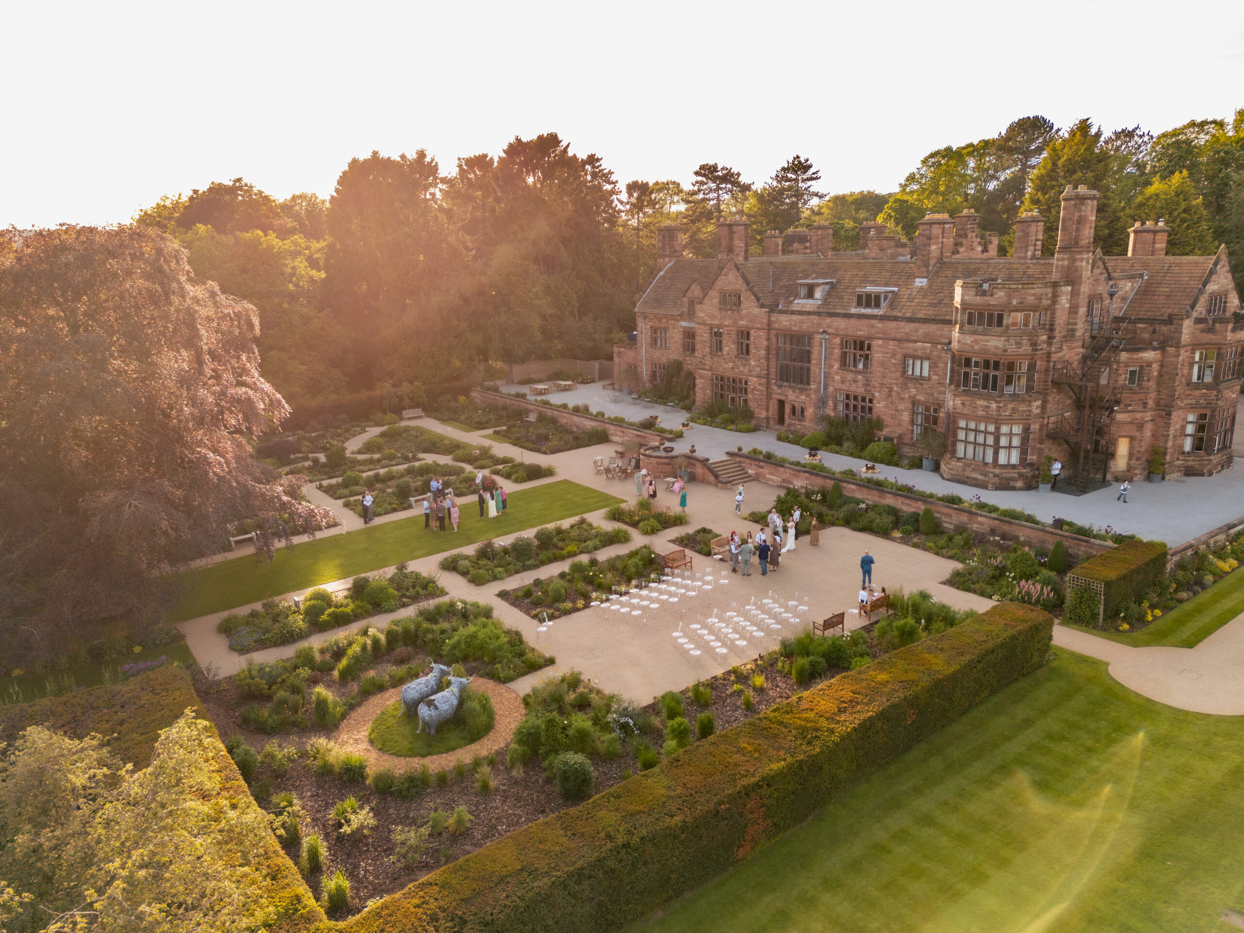 Aerial view of Salt House and guests gathered on the lawn in warm early evening light