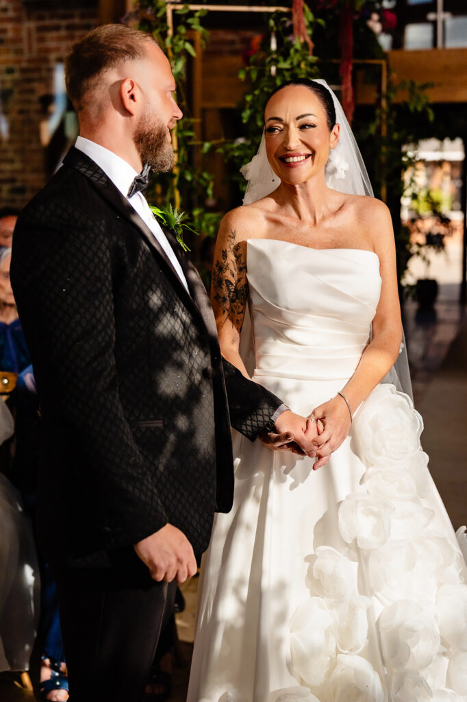 Kim and Glynn holding hands during the ceremony in the glass barn, Nottingham wedding photographer