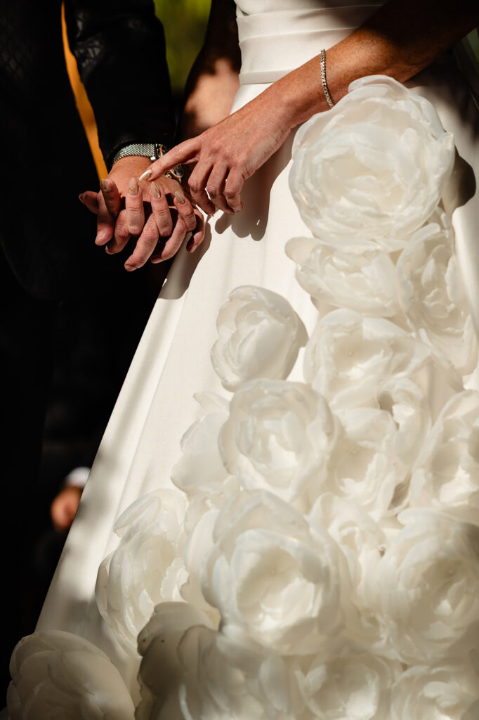 Close up of hands and wedding ring against the fabric roses of Kim's skirt, Swancar Farm wedding photographer
