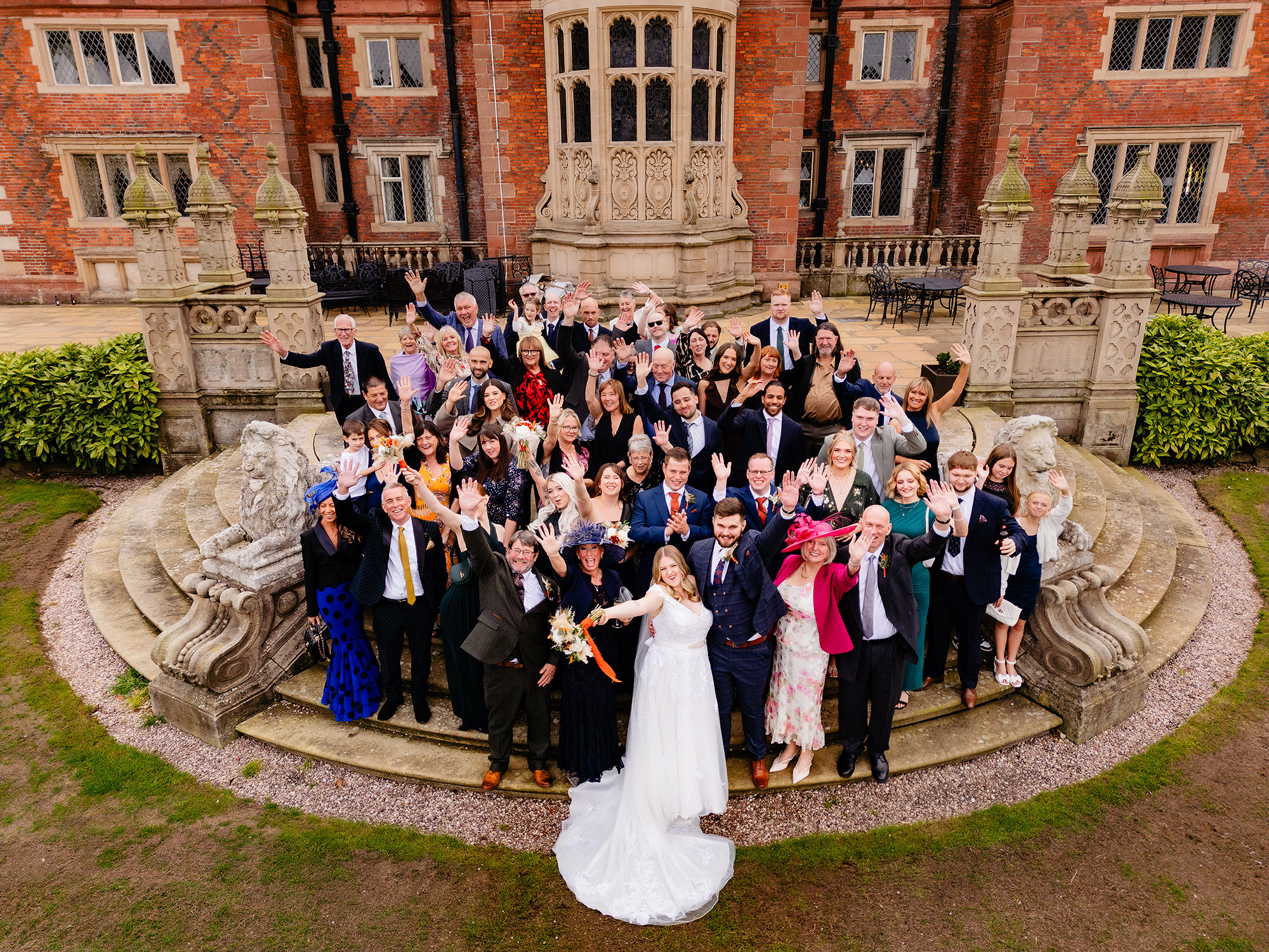 A wide shot of the whole wedding party and guests gathered by Crewe Hall’s fountain, Cheshire wedding photographer