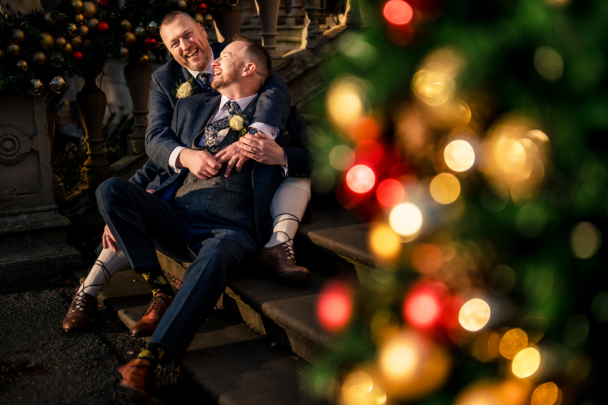 A relaxed seated portrait among the Christmas fairy lights at Crewe Hall