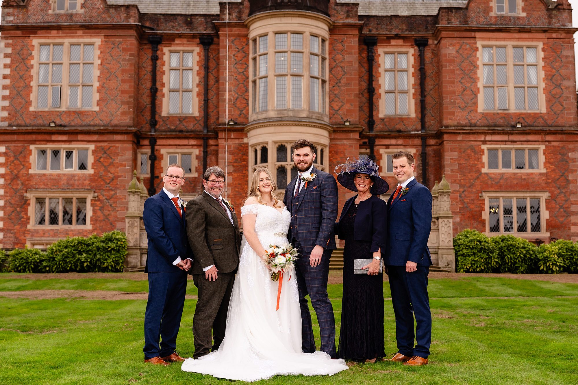 Annie with her dad, brothers and mum for the family formal photo at Crewe Hall, Cheshire wedding photographer