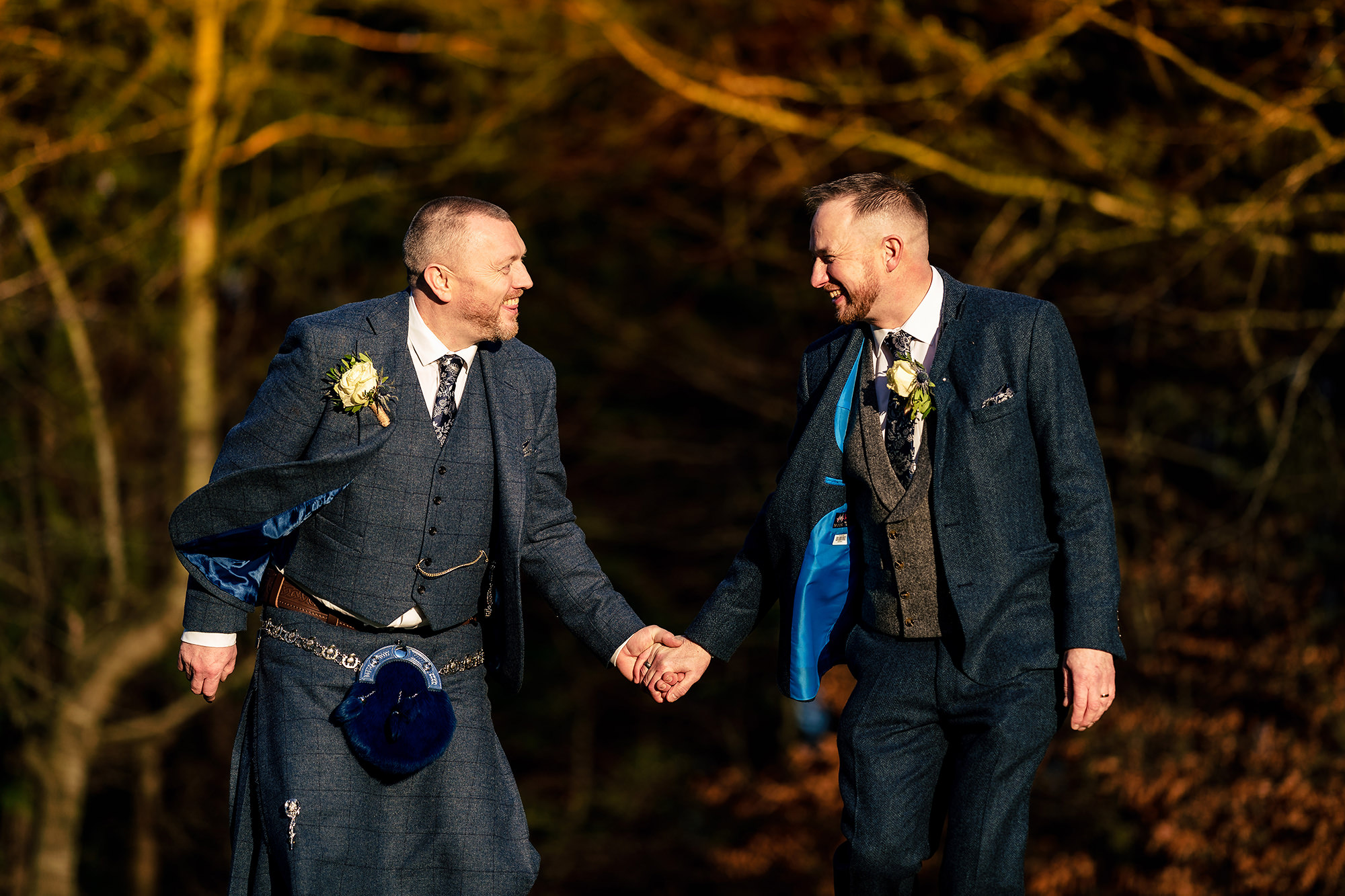 Walking hand in hand through the bare winter trees in the grounds at Crewe Hall