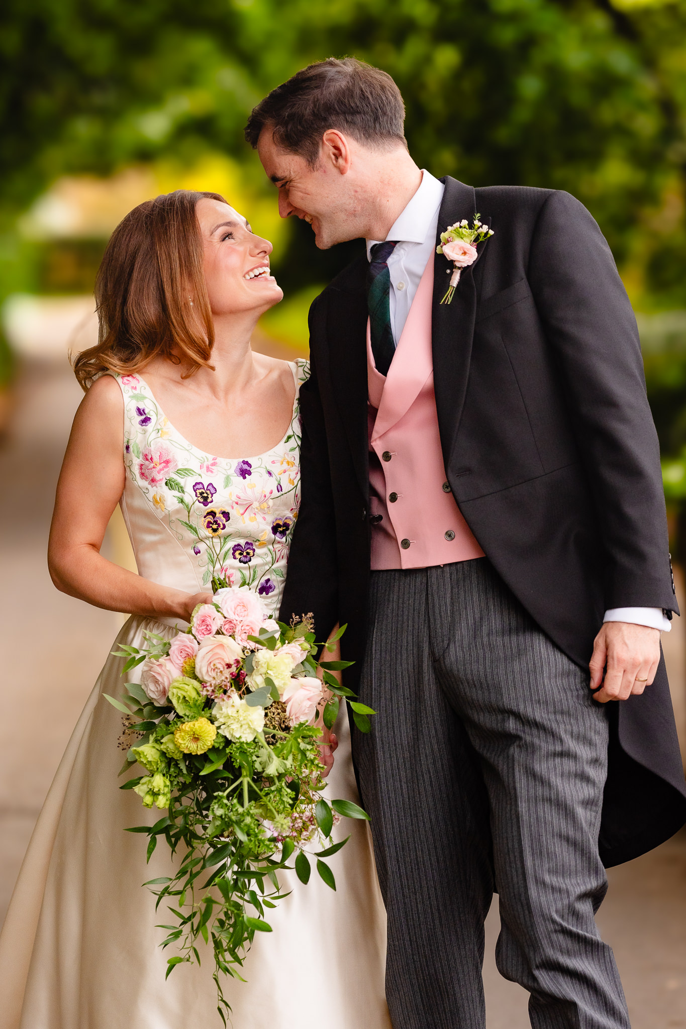Bride and groom laughing as they look at each other on a country lane, Dorset marquee wedding photographer