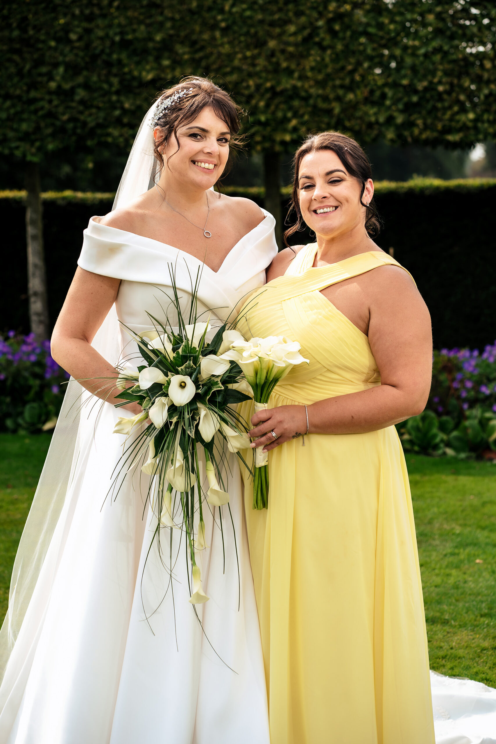 A quieter moment between Laura and one of her bridesmaids, bouquet in hand, Merrydale Manor wedding photographer
