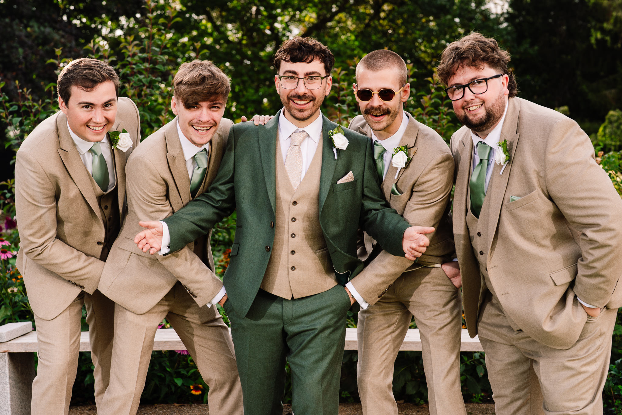 Groomsmen in tan suits laughing together for a fun group shot