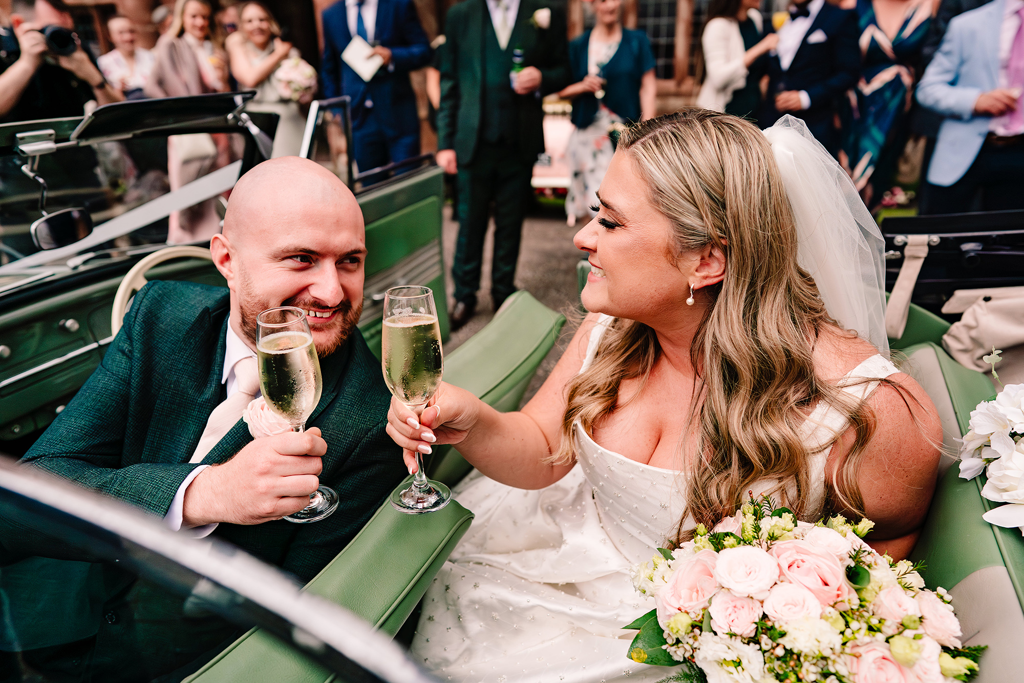 Chloe and Pete toasting champagne in the back of the wedding car