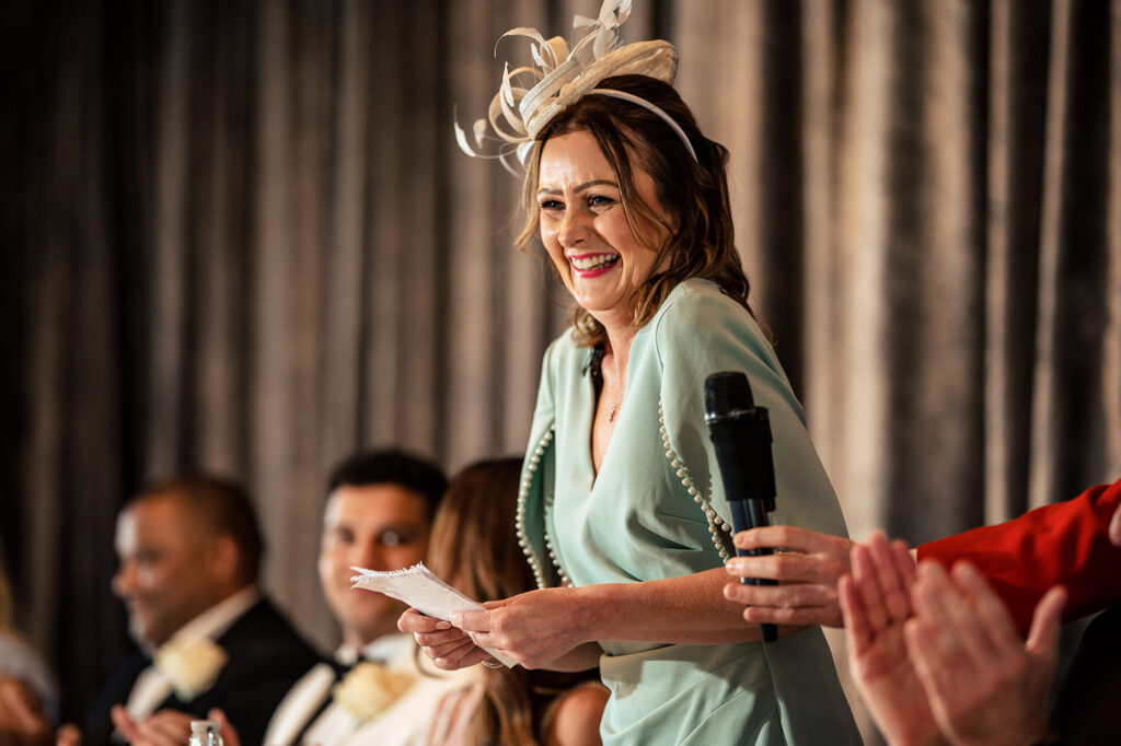 Gemma’s mum laughing as she gives her speech, with Gemma and Tyrone at the top table, Merrydale Manor wedding photographer
