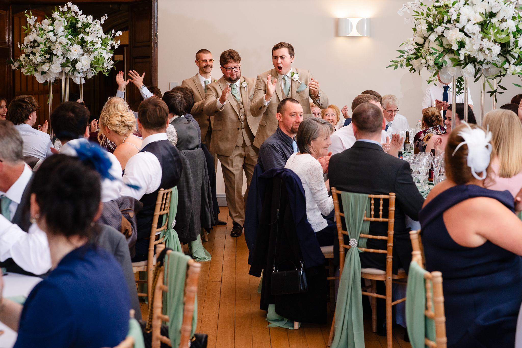 Groomsmen cheering as they lead the wedding party into the reception room at Salt House