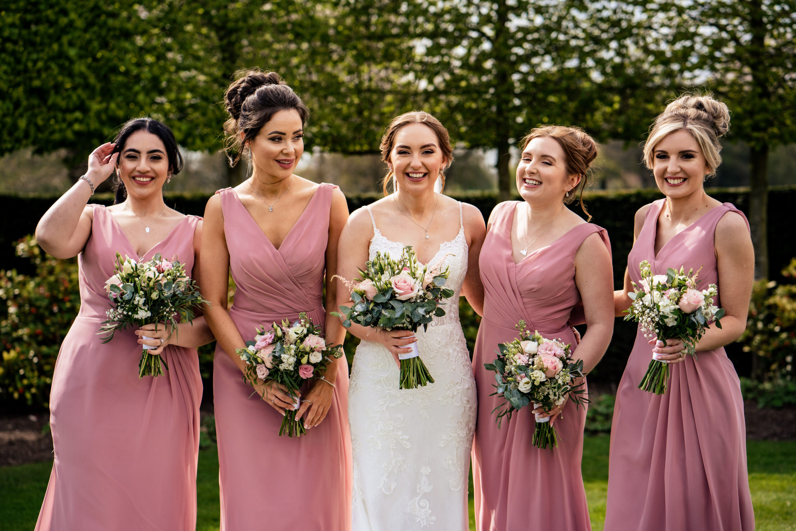 Bethany and her bridesmaids laughing in the hedge garden, Cheshire wedding photographer